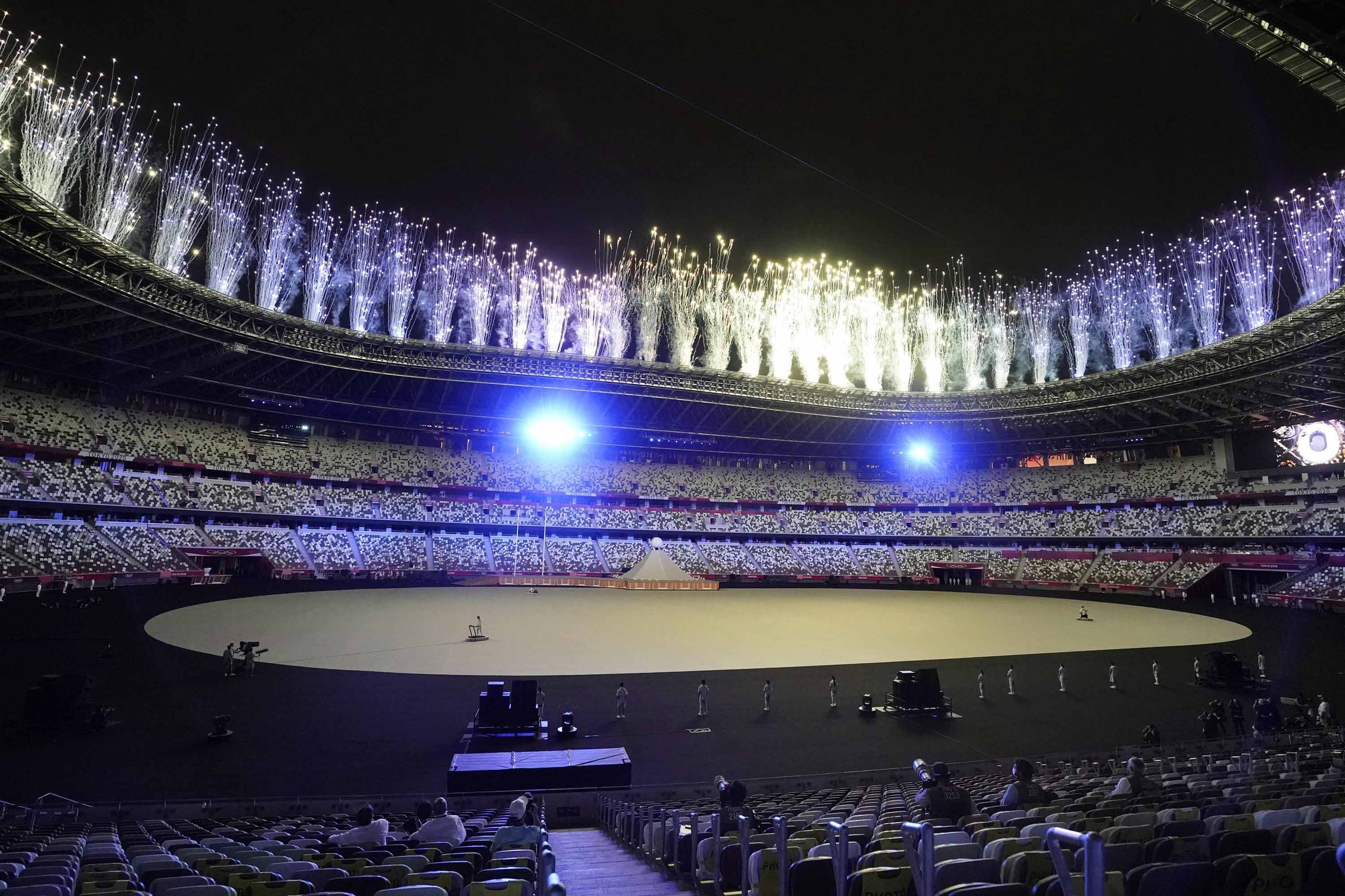 Fireworks go off above the sparsely filled Olympic Stadium during the opening ceremony.