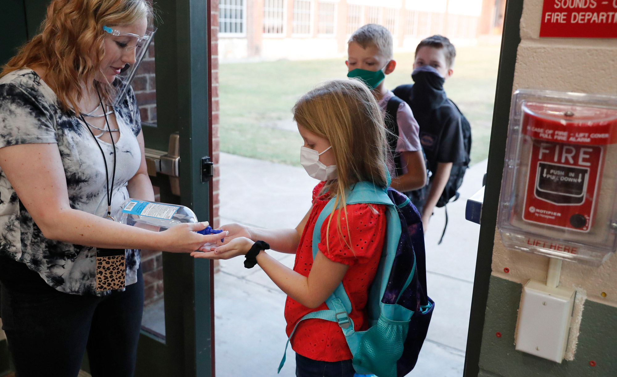 Elementary school students use hand sanitizer before entering school for classes in Godley, Texas, on August 5.