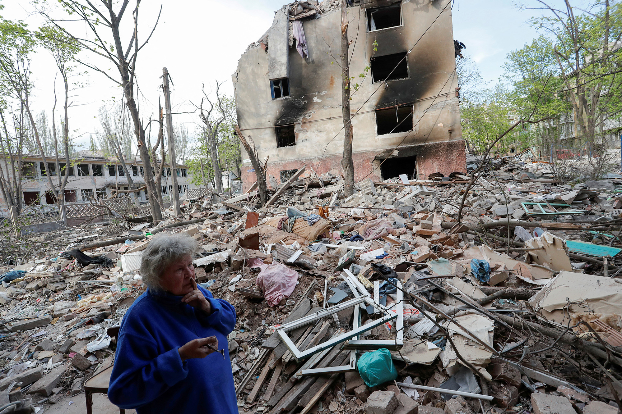 Natalya Kalugina, 64, stands in a courtyard near a block of destroyed apartment buildings in Mariupol, Ukraine on April 29.
