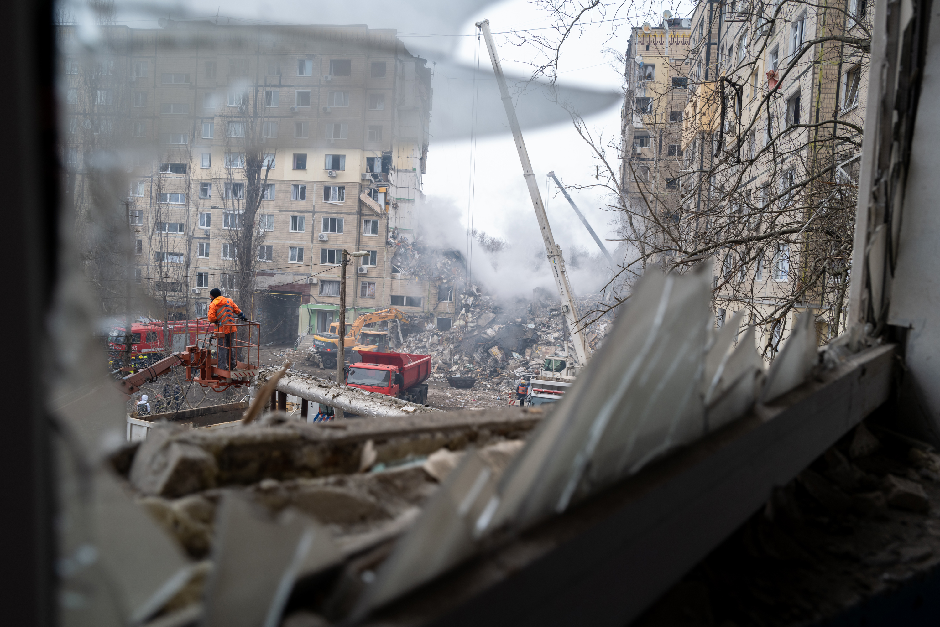 Emergency workers search the remains of an apartment building on Sunday, that was struck by a Russian missile on Saturday, in Dnipro.