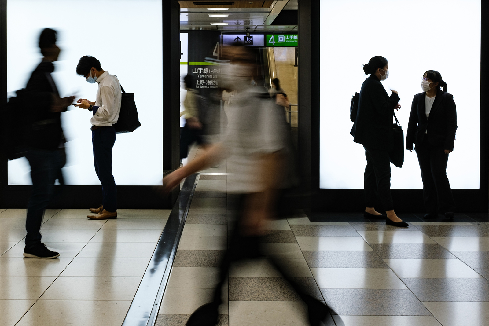 People wearing face masks gather at the Tokyo railway station on July 2.