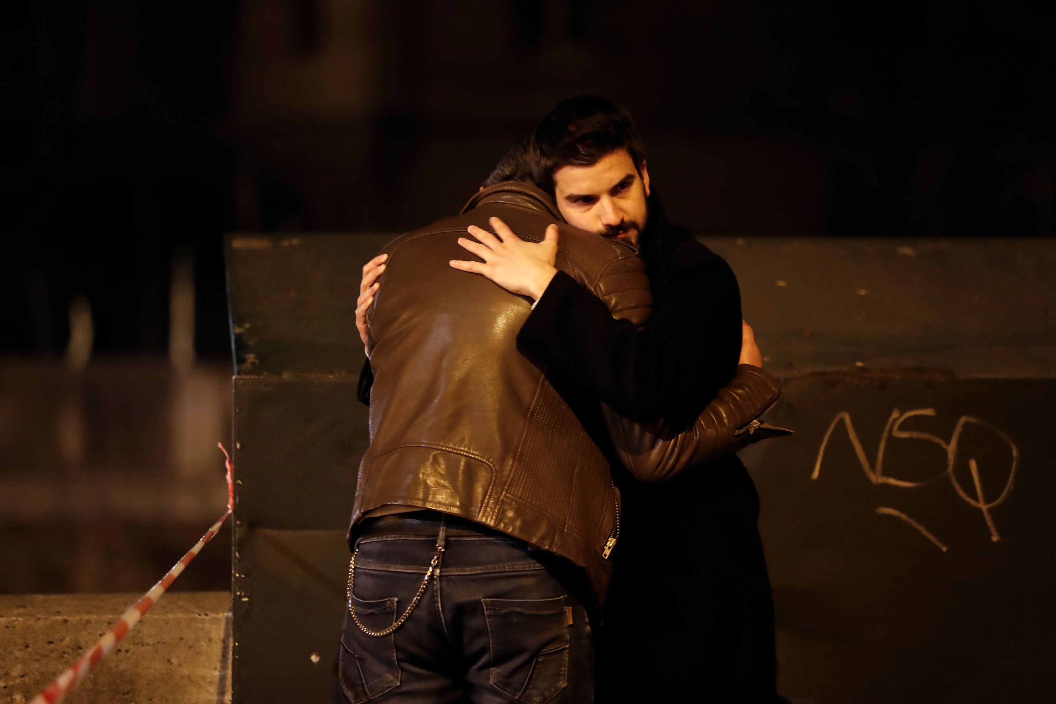 Two men hug near Notre Dame Cathedral in Paris early Tuesday morning, after a huge fire that devastated the building.