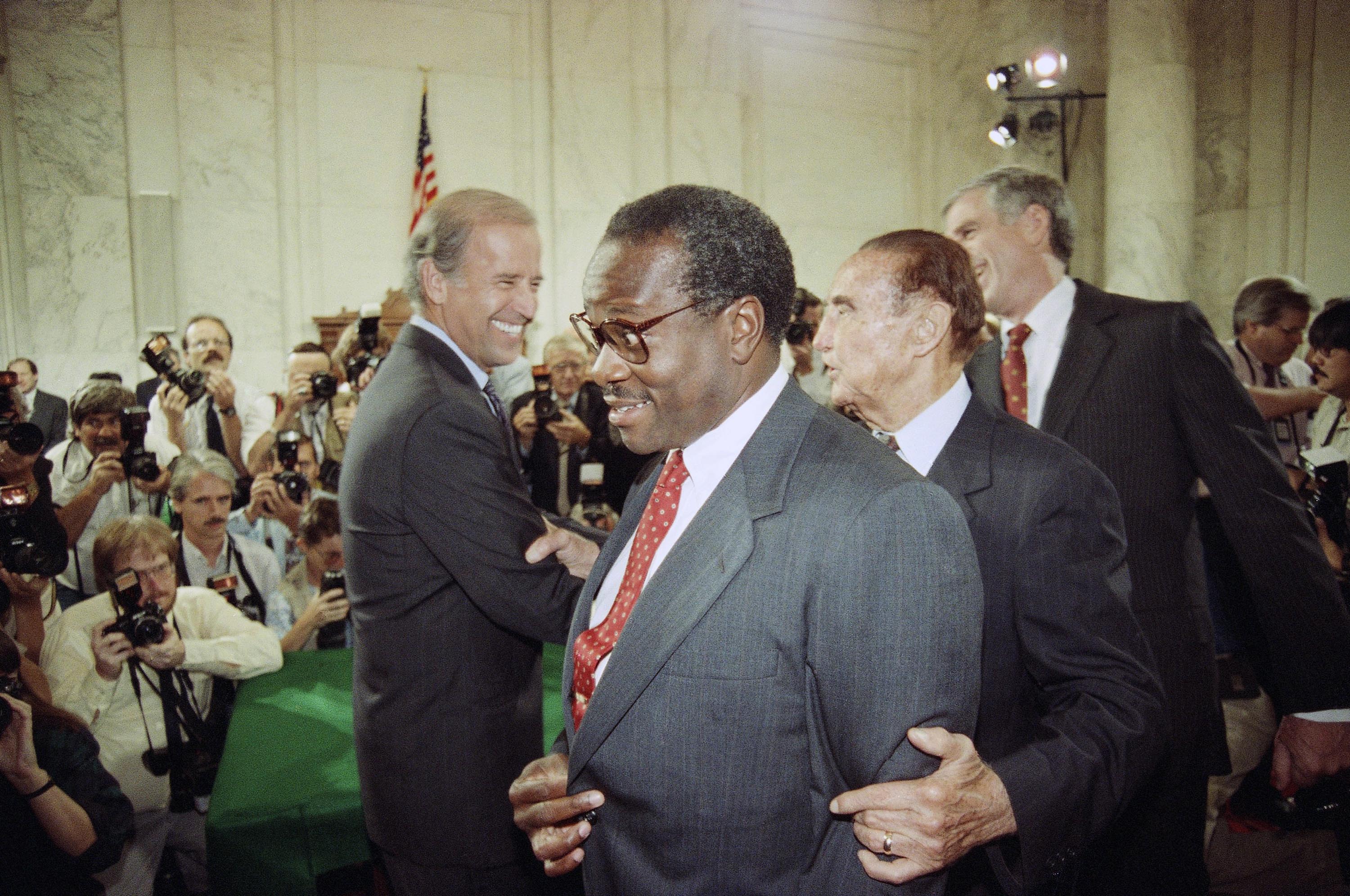 Supreme Court Justice nominee Clarence Thomas is escorted by Sen. Strom Thurmond, second from right, and Sen. John Danforth, right, while walking past then-Senate Judiciary Committee Chairman, Sen. Joseph Biden (D-Del.), left, on Capitol Hill in September 1991, prior to the start of Thomas's nomination hearing.