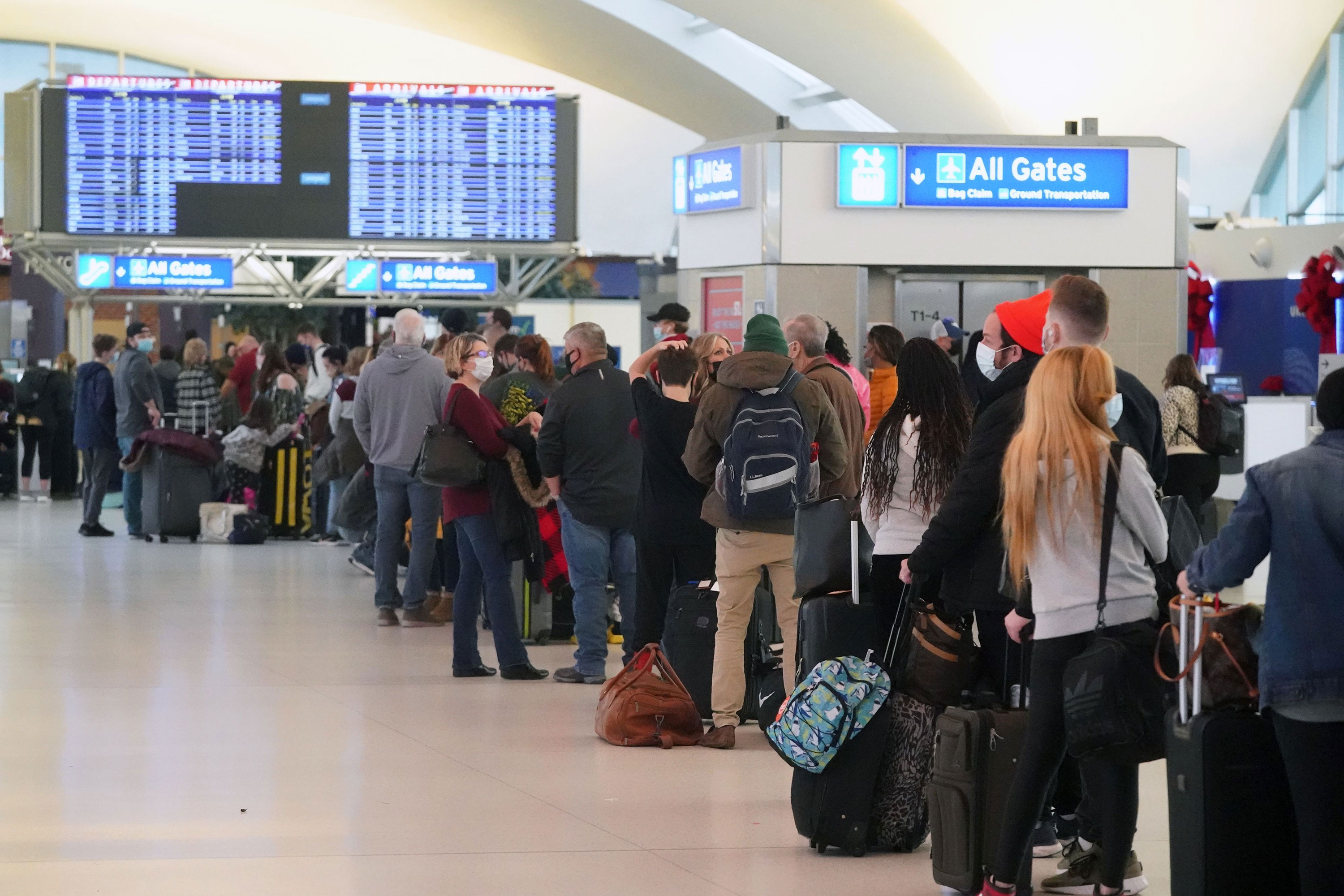Passengers wait in line for alternative airlines at St. Louis-Lambert International Airport in St. Louis on Sunday, December 26, 2021. 