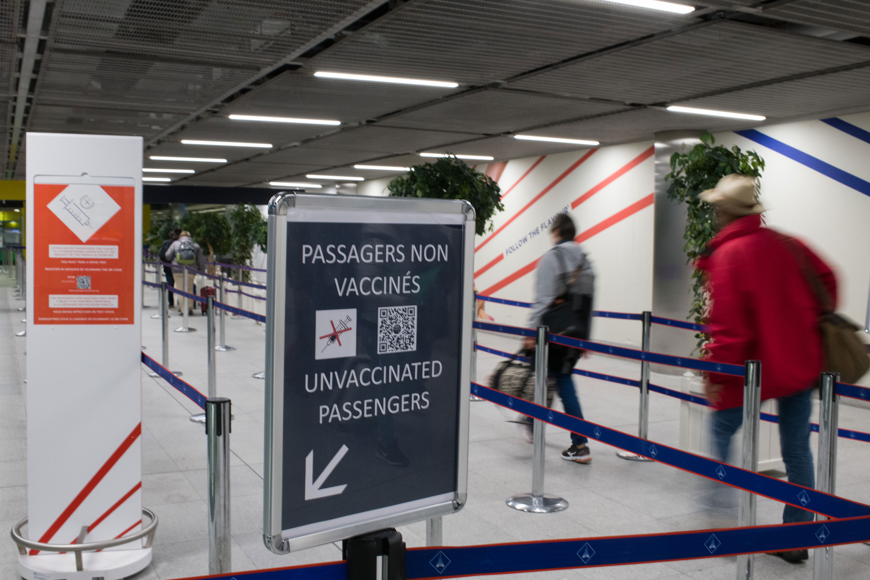 Visitors walk past a sign for unvaccinated passengers at Charles de Gaulle airport in Paris on December 14.
