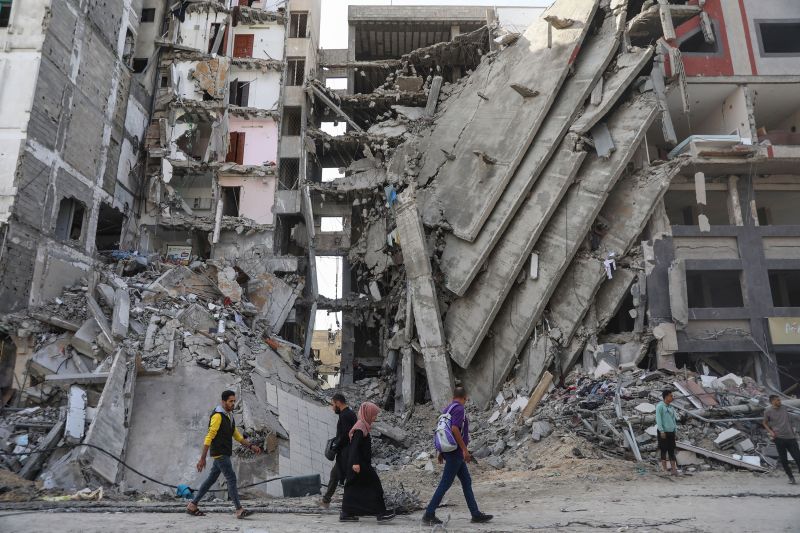 Palestinians walk through destruction in Gaza City on November 24, as the temporary truce between Israel and Hamas comes into effect. 