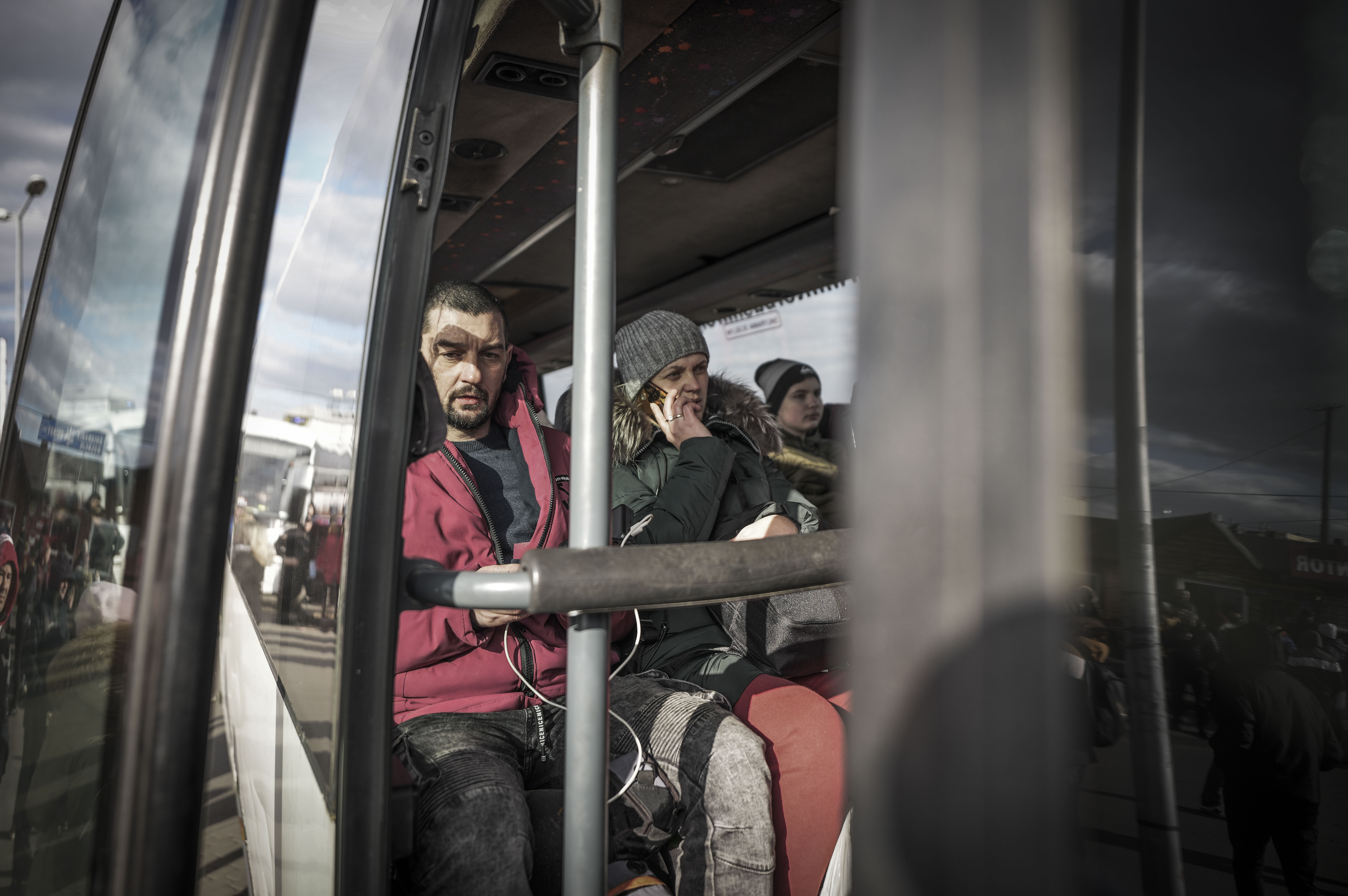 Refugees from Ukraine sit on a bus taking them to a temporary shelter after crossing the border from Shehyni in Ukraine to Medyka, Poland, on February 25.