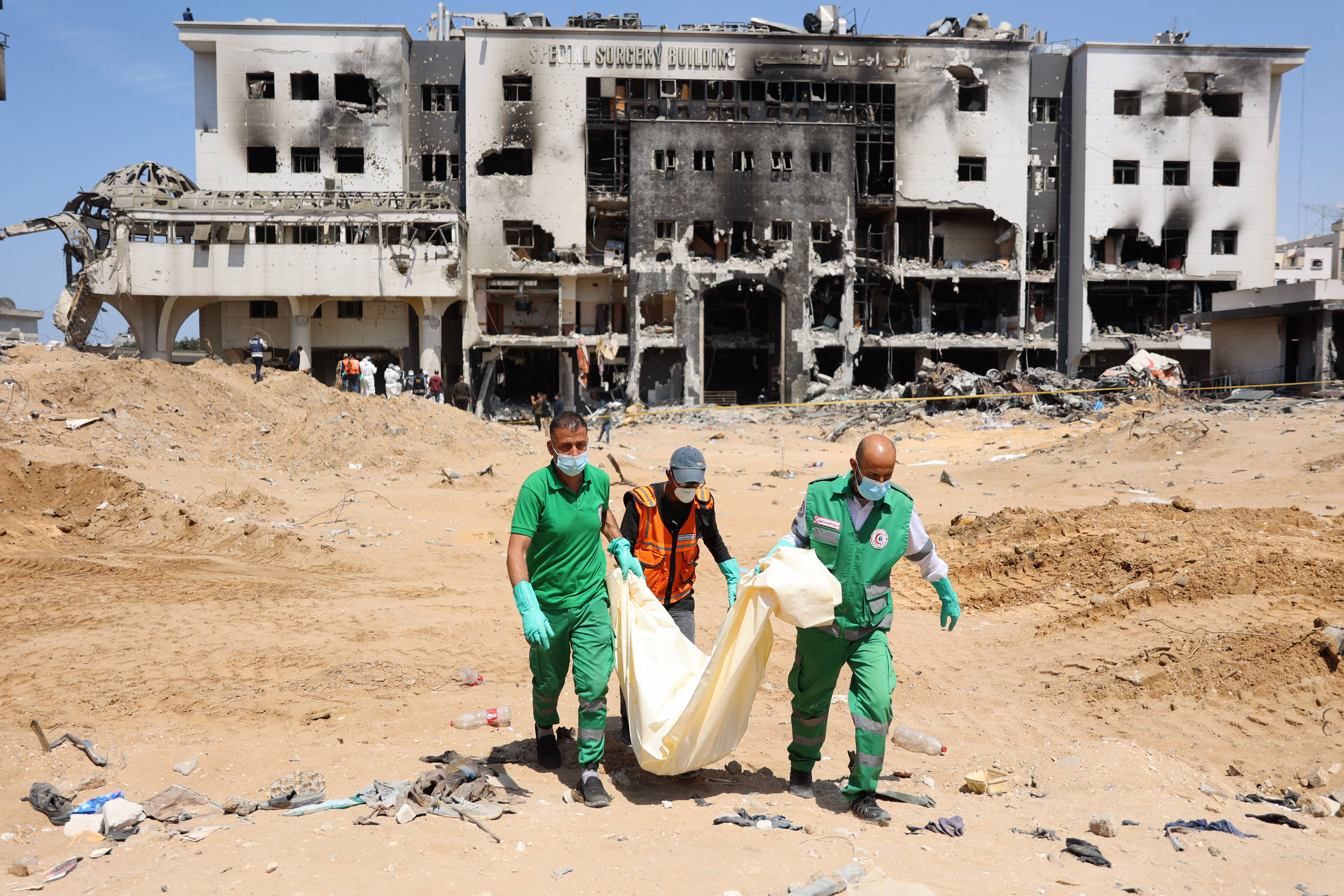 Palestinian forensic and civil defense workers recover human remains at the grounds of Al-Shifa Hospital, Gaza, on April 8.