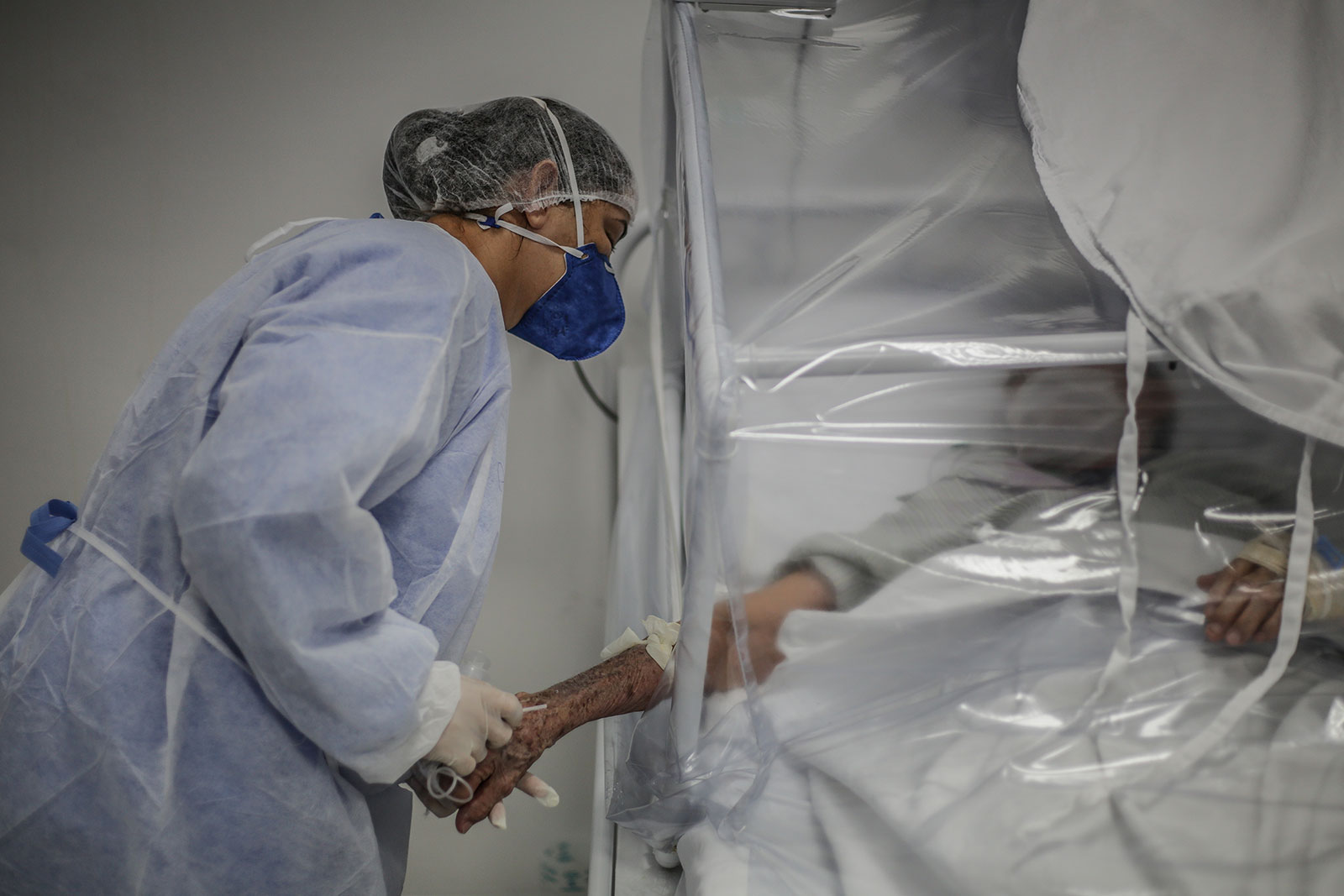 A nurse holds the arm of a coronavirus patient at a field hospital in Manaus on May 21.