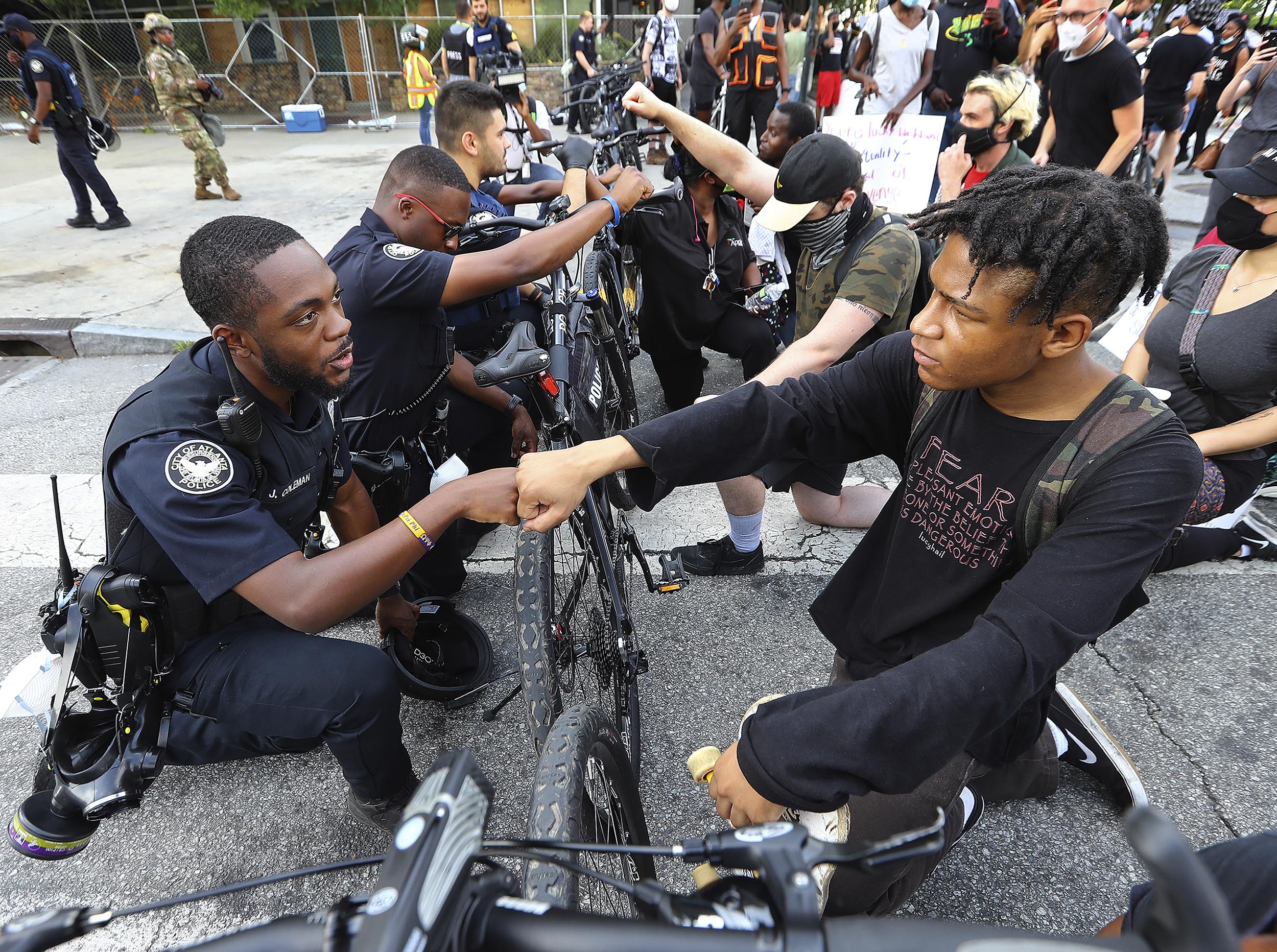 Atlanta Police Officer J. Coleman, left, and protester Elijah Raffington, of Sandy Springs, fist bump during a George Floyd protest at Centennial Olympic Park Drive in Atlanta, Georgia, on Wednesday, June 3. 