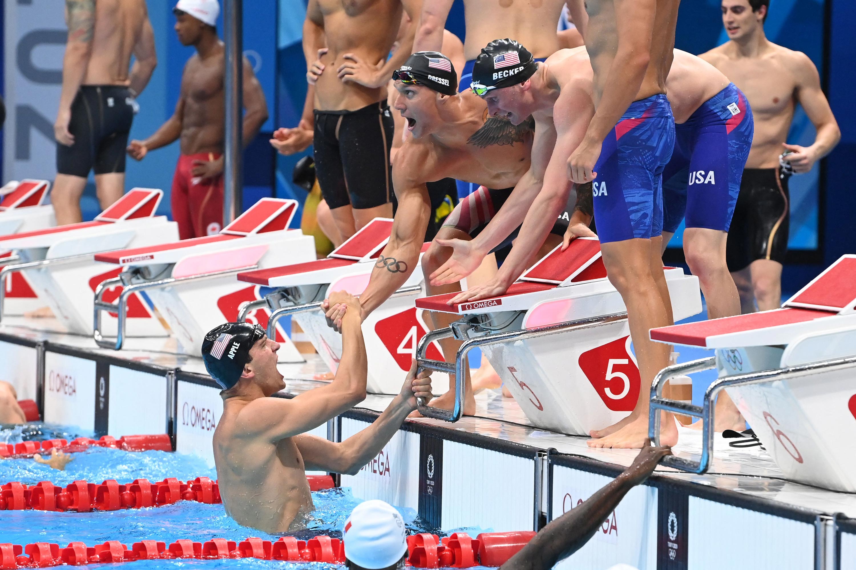 USA's Zach Apple, left, celebrates with teammates Caeleb Dressel, Blake Pieroni and Bowen Becker after taking gold in the final of the 4x100m freestyle relay swimming event on July 26.