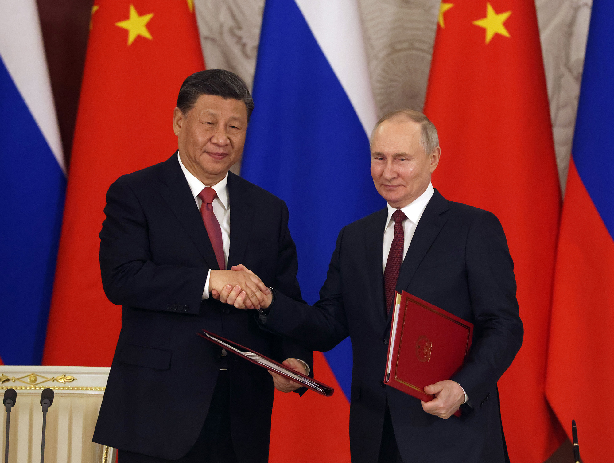 Chinese President Xi Jinping, left, and Russian President Vladimir Putin shake hands during a document signing ceremony at the Grand Kremlin Palace in Moscow, Russia, on March 21.