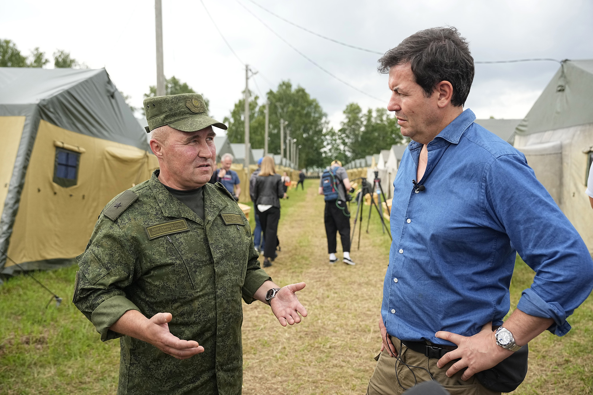 Maj. Gen. Leonid Kosinsky, left, speaks with CNN journalist Matthew Chance in the Belarusian army camp near Tsel village, Belarus, on July 7.