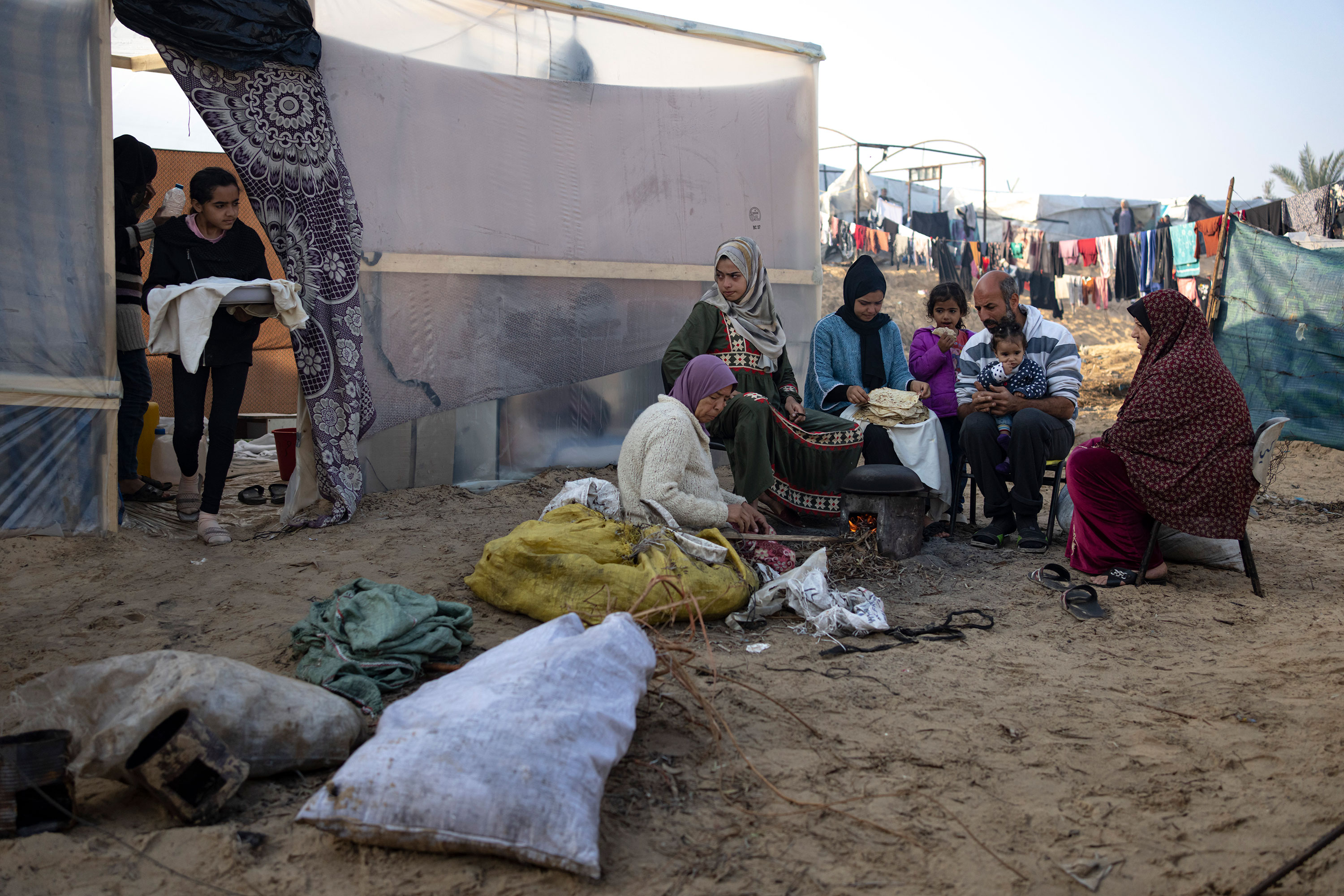 Members of the Abu Jarad family, who were displaced by the Israeli bombardment of Gaza, bake bread at a makeshift tent camp in the Muwasi area of southern Gaza on January 1. 