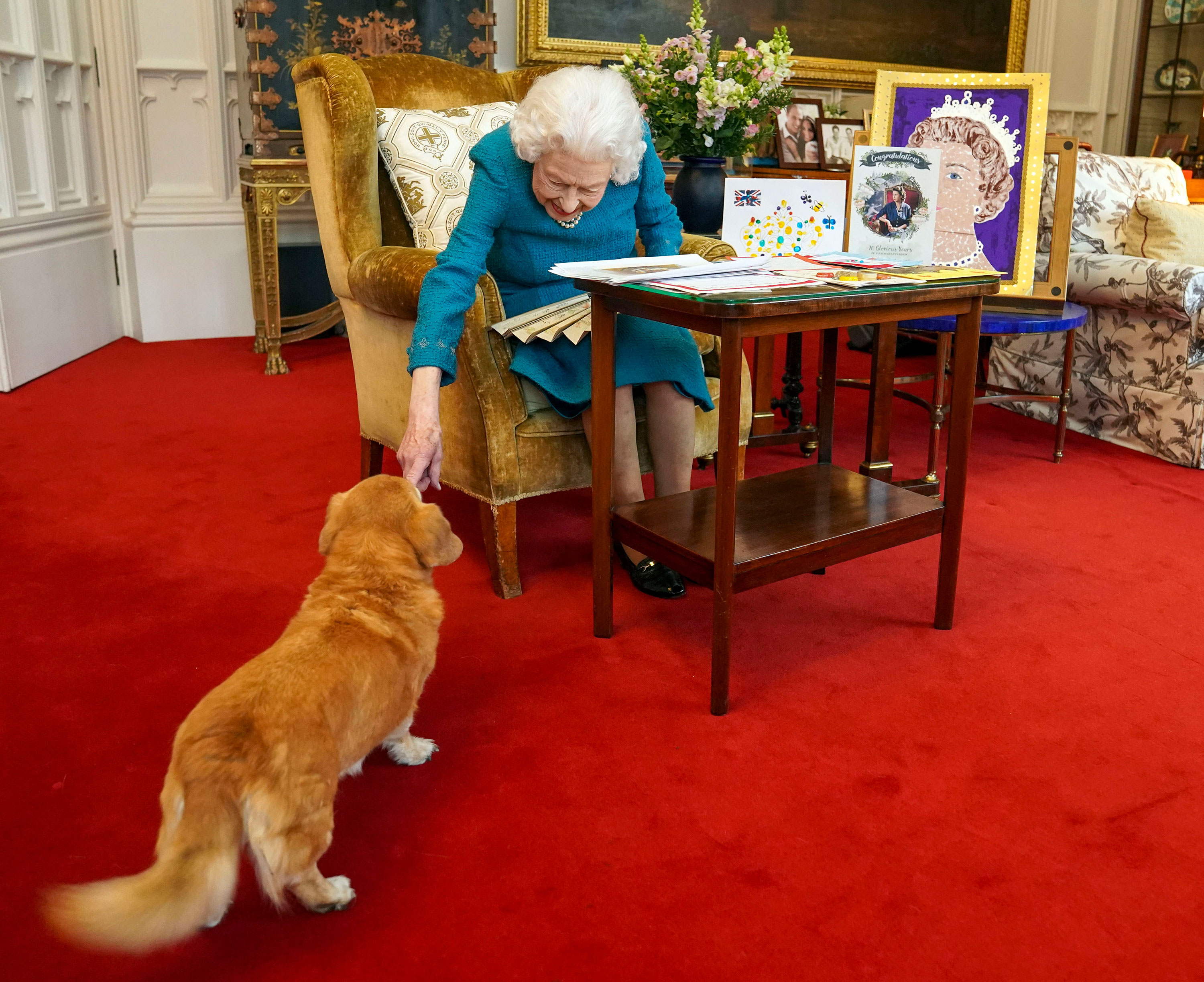 Queen Elizabeth is joined by her "dorgi" called Candy as she views a display of memorabilia from her Golden and Platinum Jubilees in February.