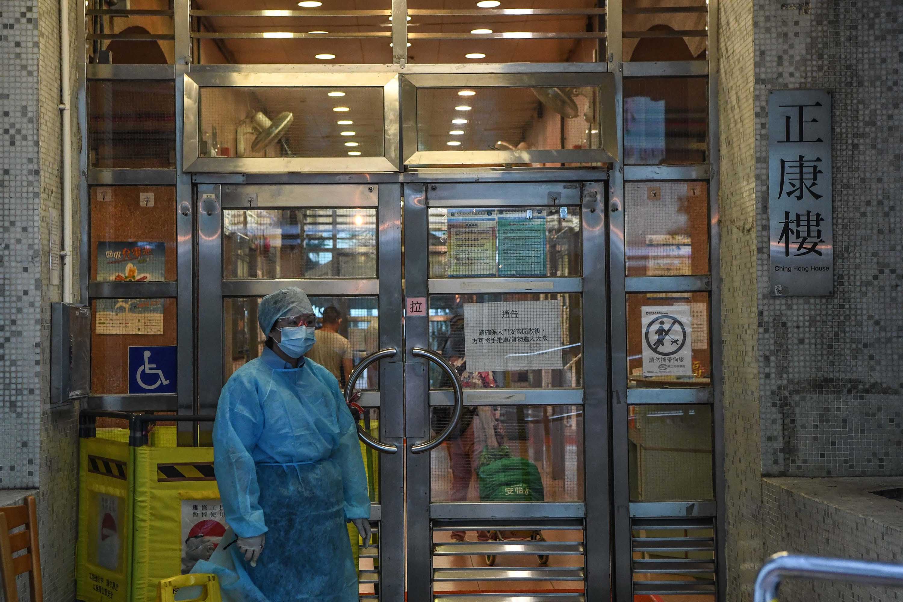 A health worker outside a residential building in Hong Kong where a case was confirmed on July 11.  