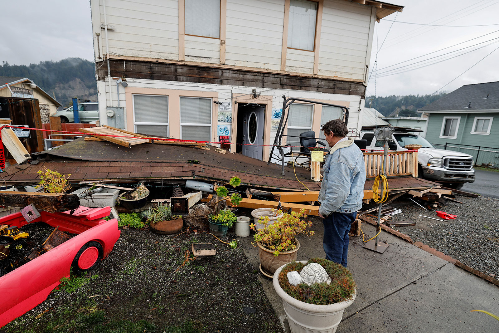 Darren Gallagher looks at the collapsed second story porch of his house after an earthquake struck off the coast of northern California, in Rio Dell on December 20.