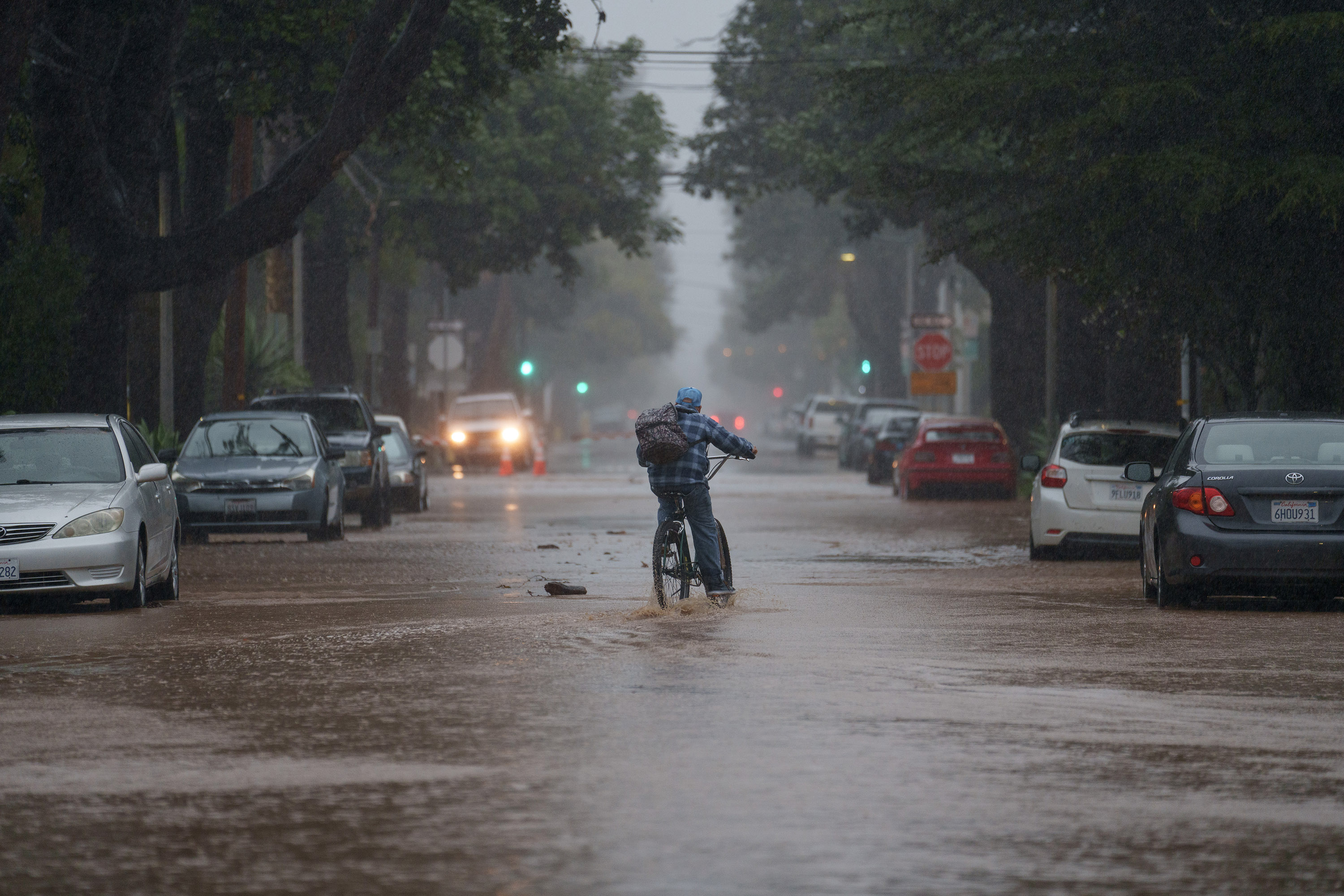 A person rides a bike through floodwaters during a storm in Santa Barbara, California, on Sunday, Februar 4.