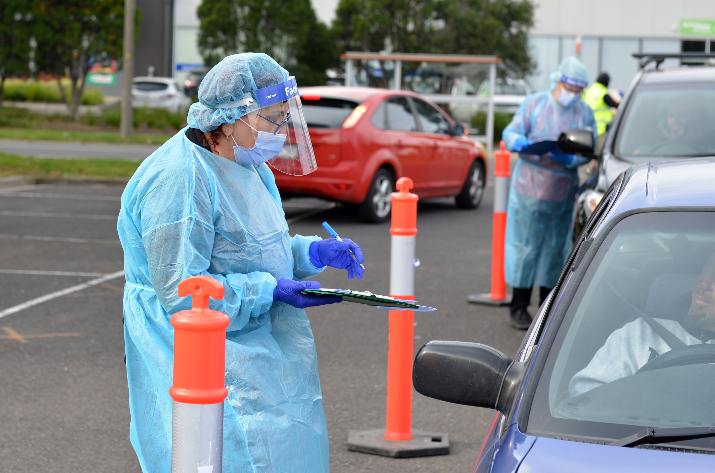 Medical workers check patients for COVID-19 at a drive-thru testing center in Melbourne, Australia on July 10, 2020. 