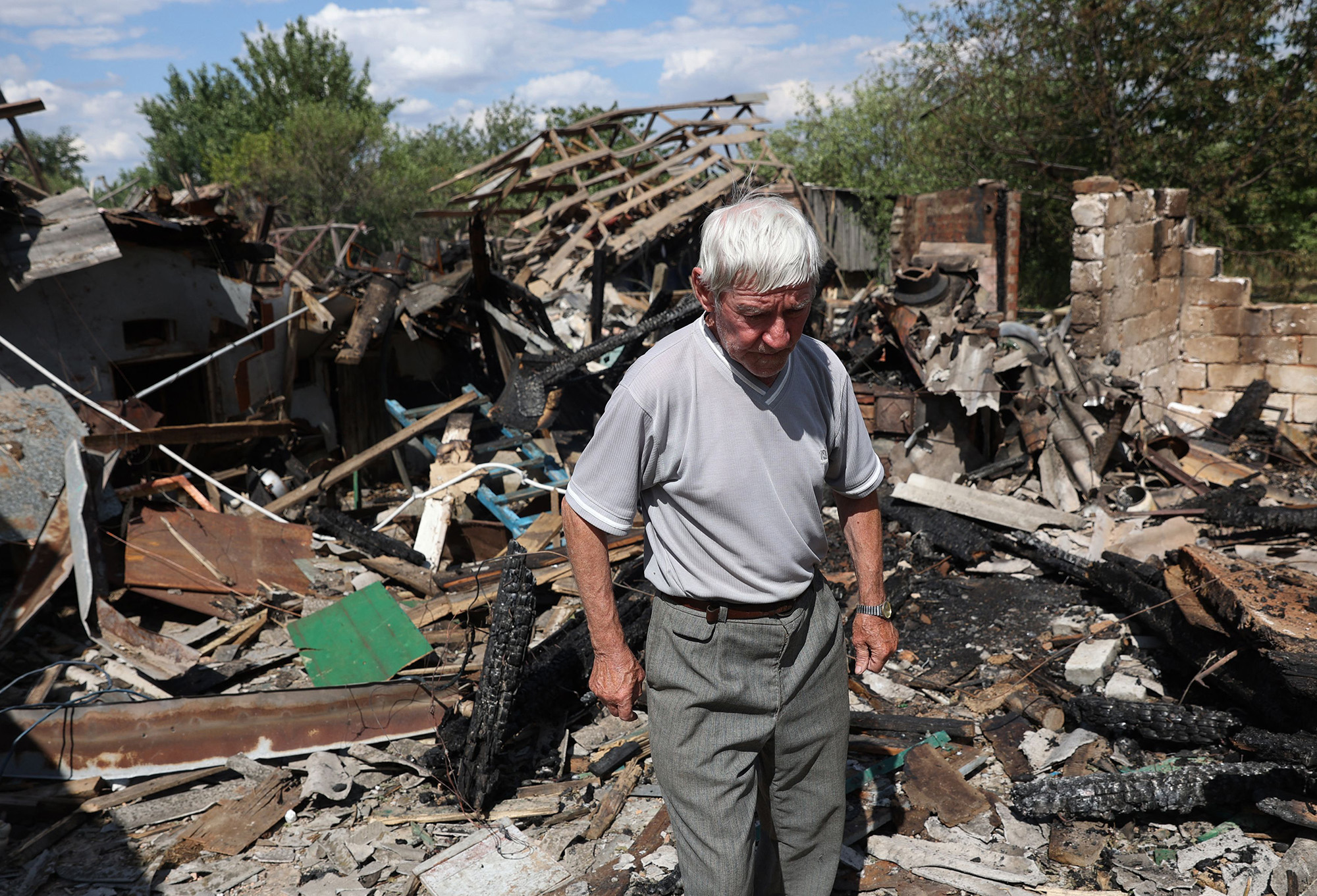 A resident stands next to his home that was shelled in Bakhmut, Ukraine on July 13.