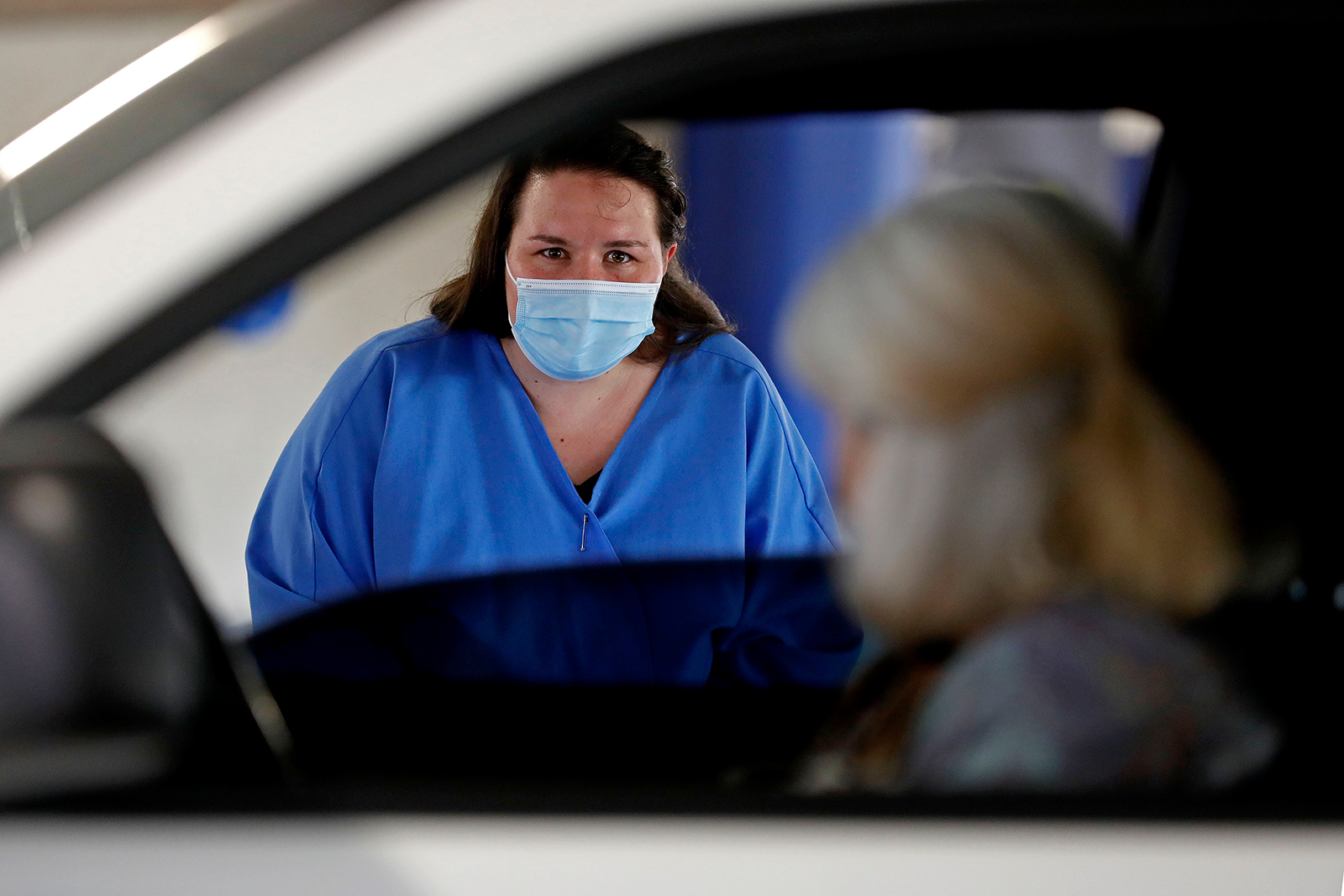 A Dis-Chem Pharmacy health professional speaks to a woman before conducting a coronavirus test at a drive-through testing site at a mall in Centurion, South Africa, on December 16.