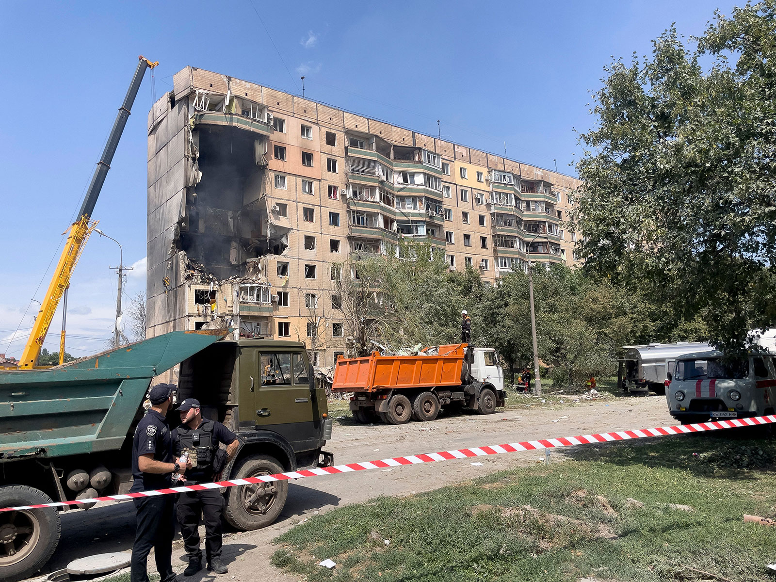 Police officers stand guard near a residential building partially destroyed as a result of a missile strike in Kryvyi Rih on Monday.