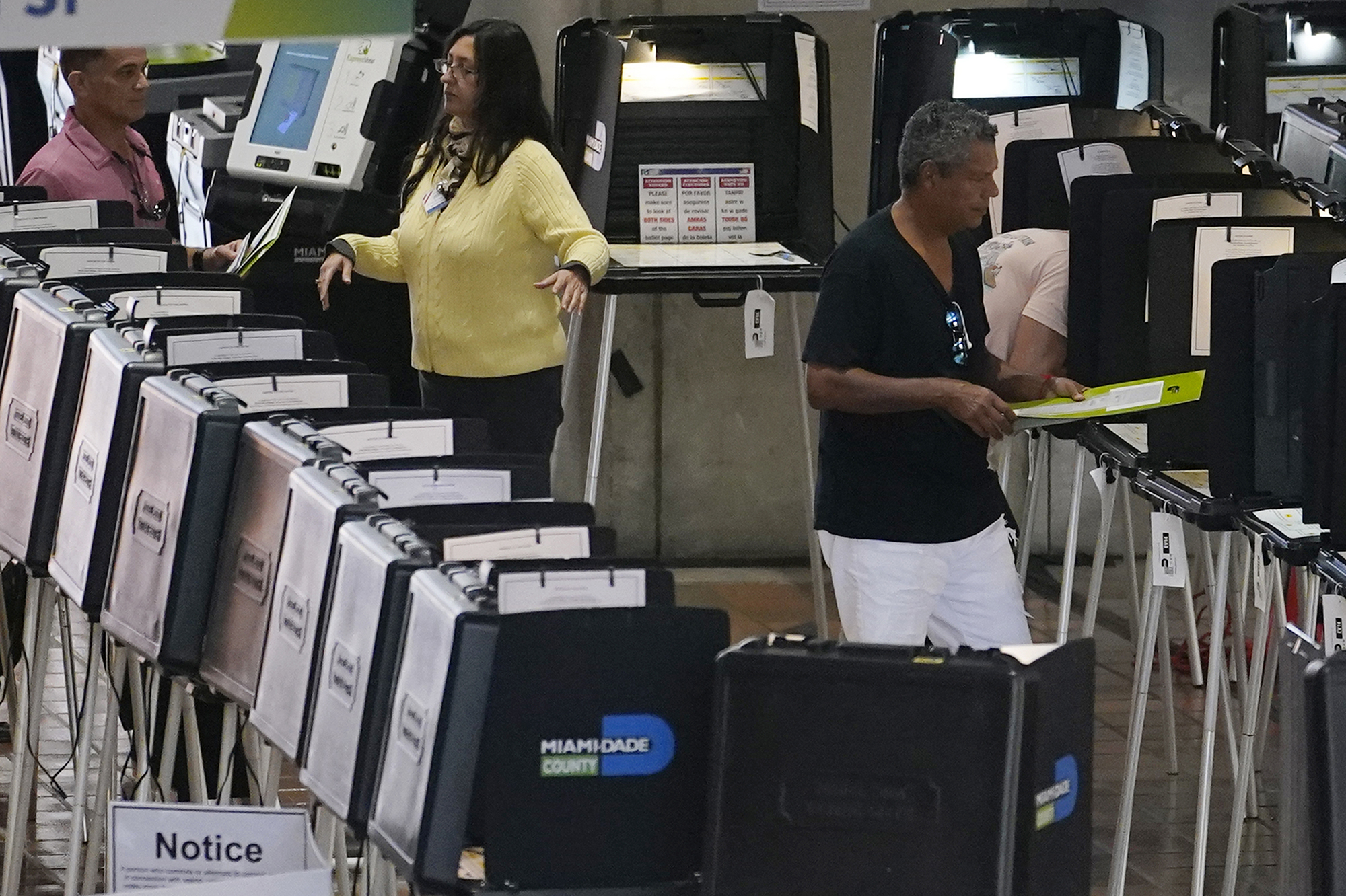 A poll worker directs voters at an early voting site in Miami on Monday, October 31, 2022.