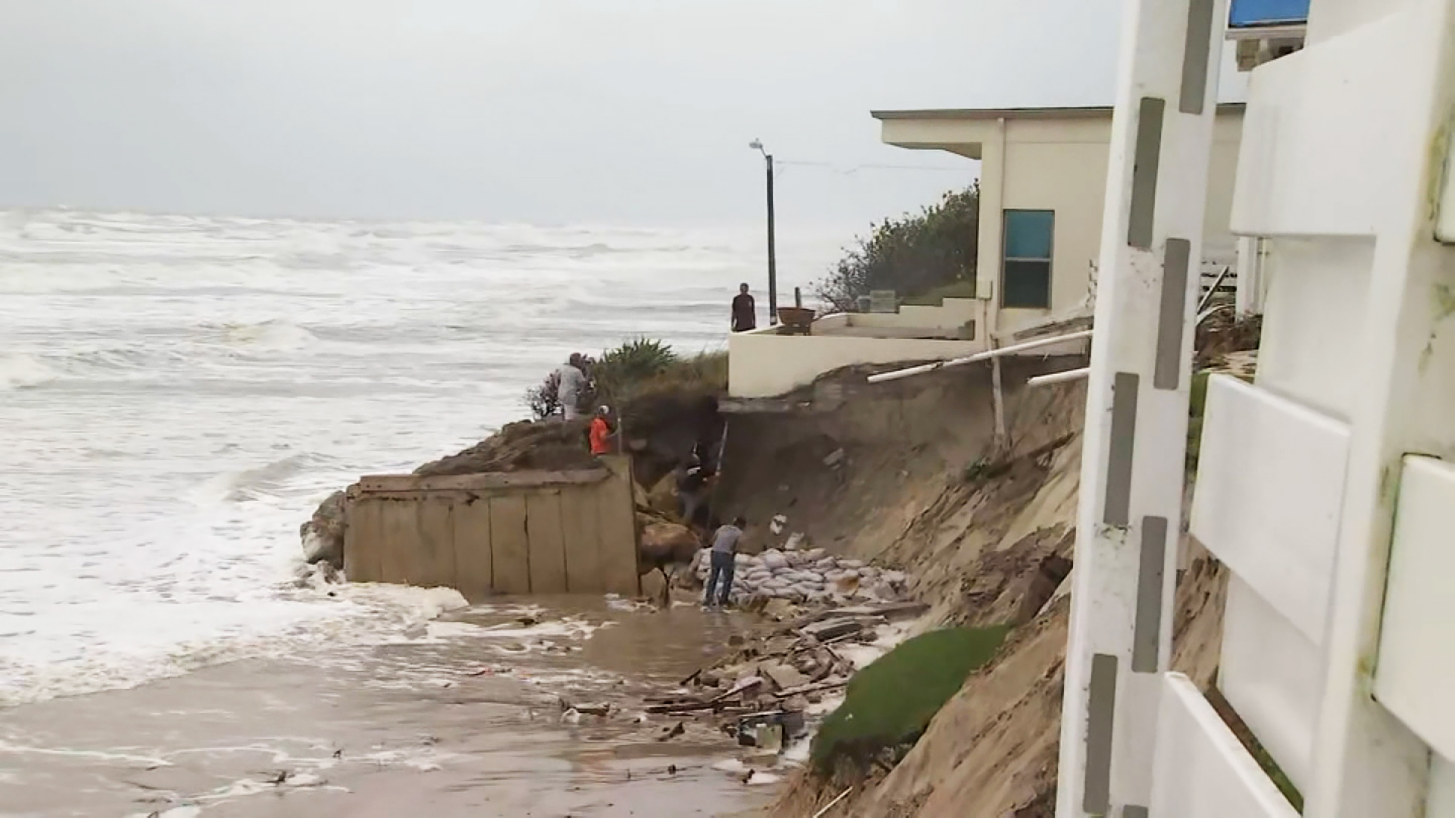 Part of a home in Wilbur-By-The-Sea -- seen Wednesday before Nicole came ashore -- was left on the edge of a cliff after surge pushed by Nicole's outer edges washed parts of the beach away.