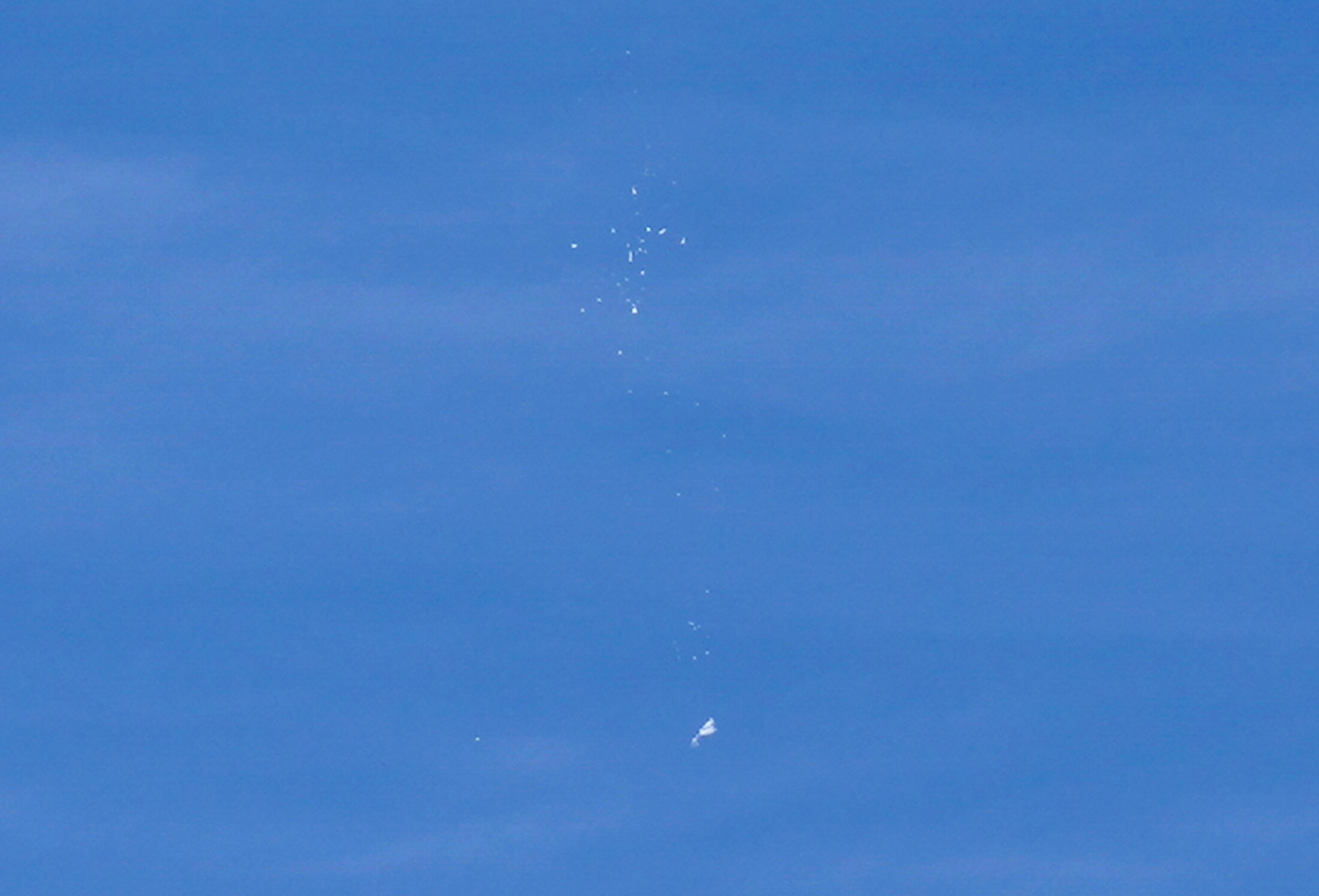 The suspected Chinese spy balloon falls to the ground, seen from Holden Beach on Saturday, February 4. 