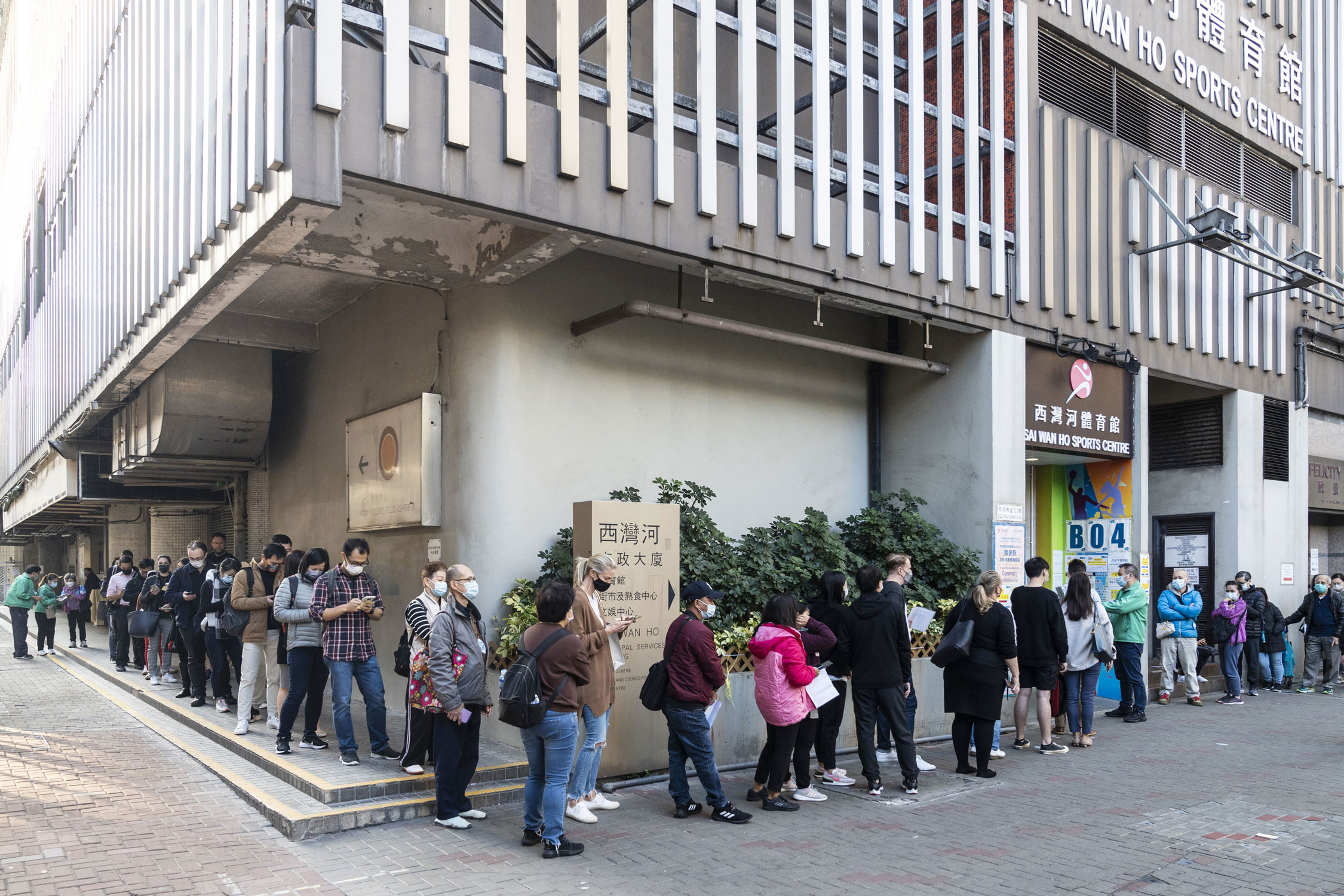 People queue outside a community vaccination center administering the BioNTech Covid-19 vaccine in Hong Kong, China, on Tuesday.