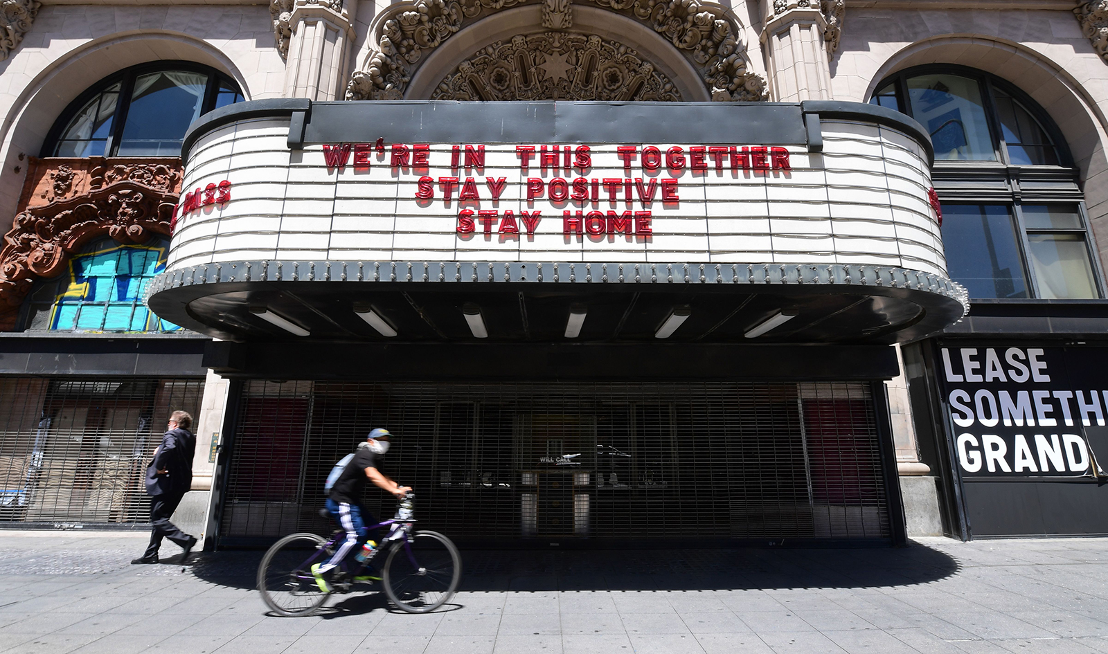 A cyclist rides past the closed Million Dollar Theater, in Los Angeles, on Monday, May 4.