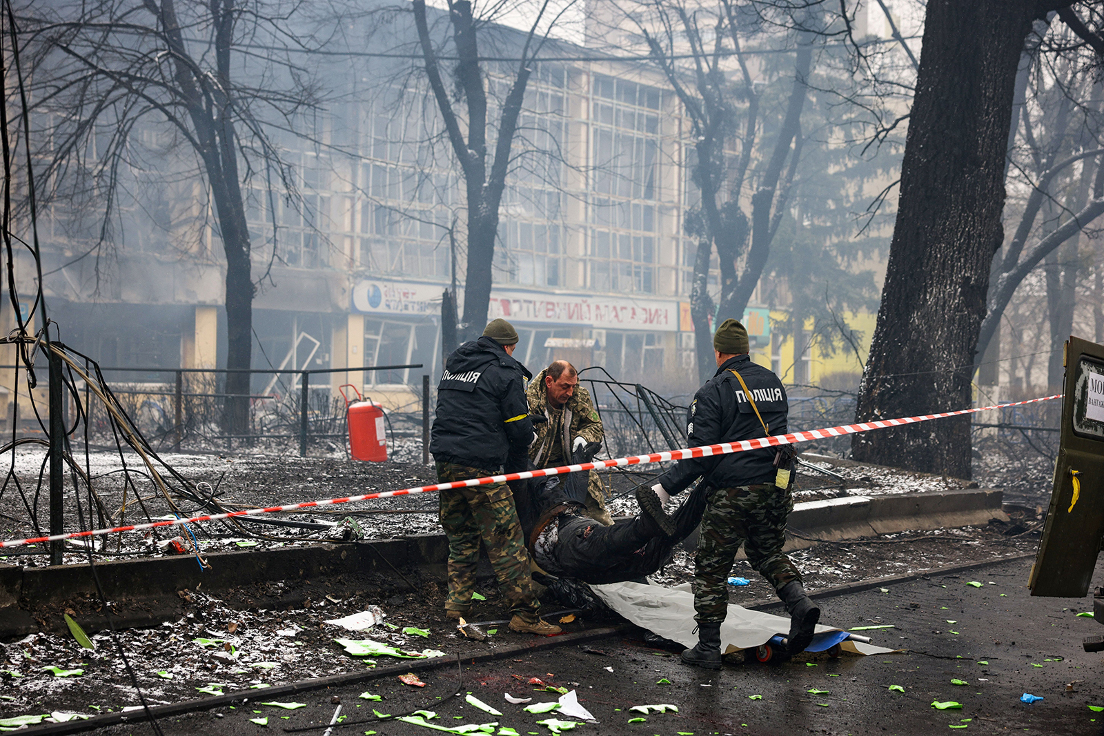Police officers remove the body of a passerby on March 2 after an airstrike that hit Kyiv's main television tower in Kyiv, Ukraine, the previous day.