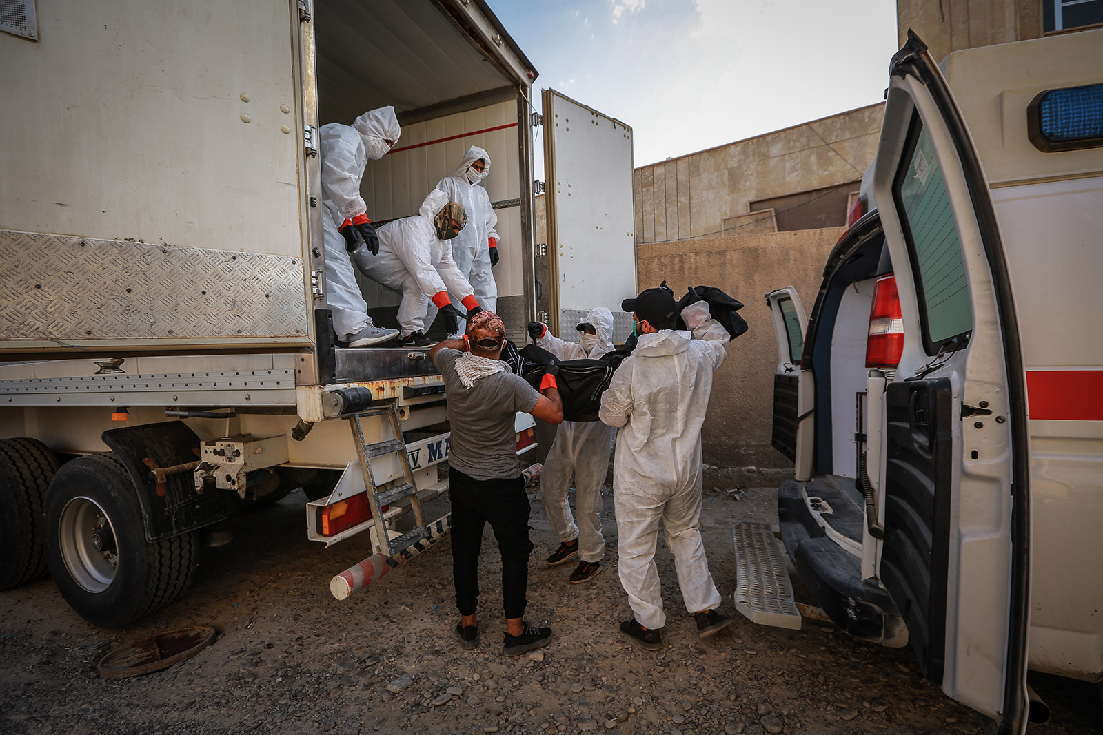Bodies of coronavirus victims are loaded onto a truck on July 11 to be transported from a hospital in Baghdad to a cemetery in Najaf, Iraq.