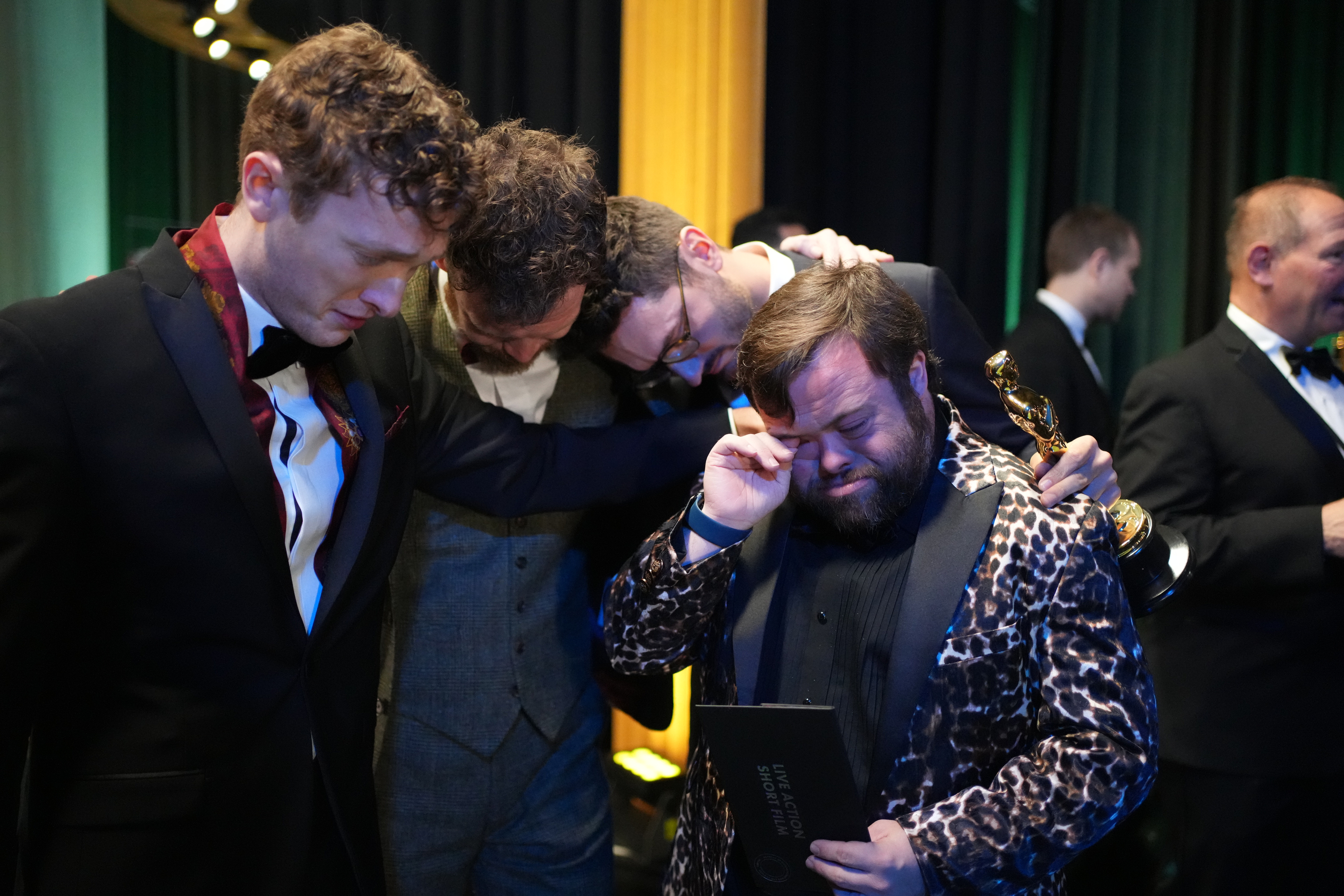 Ross White, Seamus O'Hara, Tom Berkeley e James Martin condividono un momento emozionante nel backstage dopo che "The Irish Goodbye" ha vinto l'Oscar per il miglior cortometraggio live action.