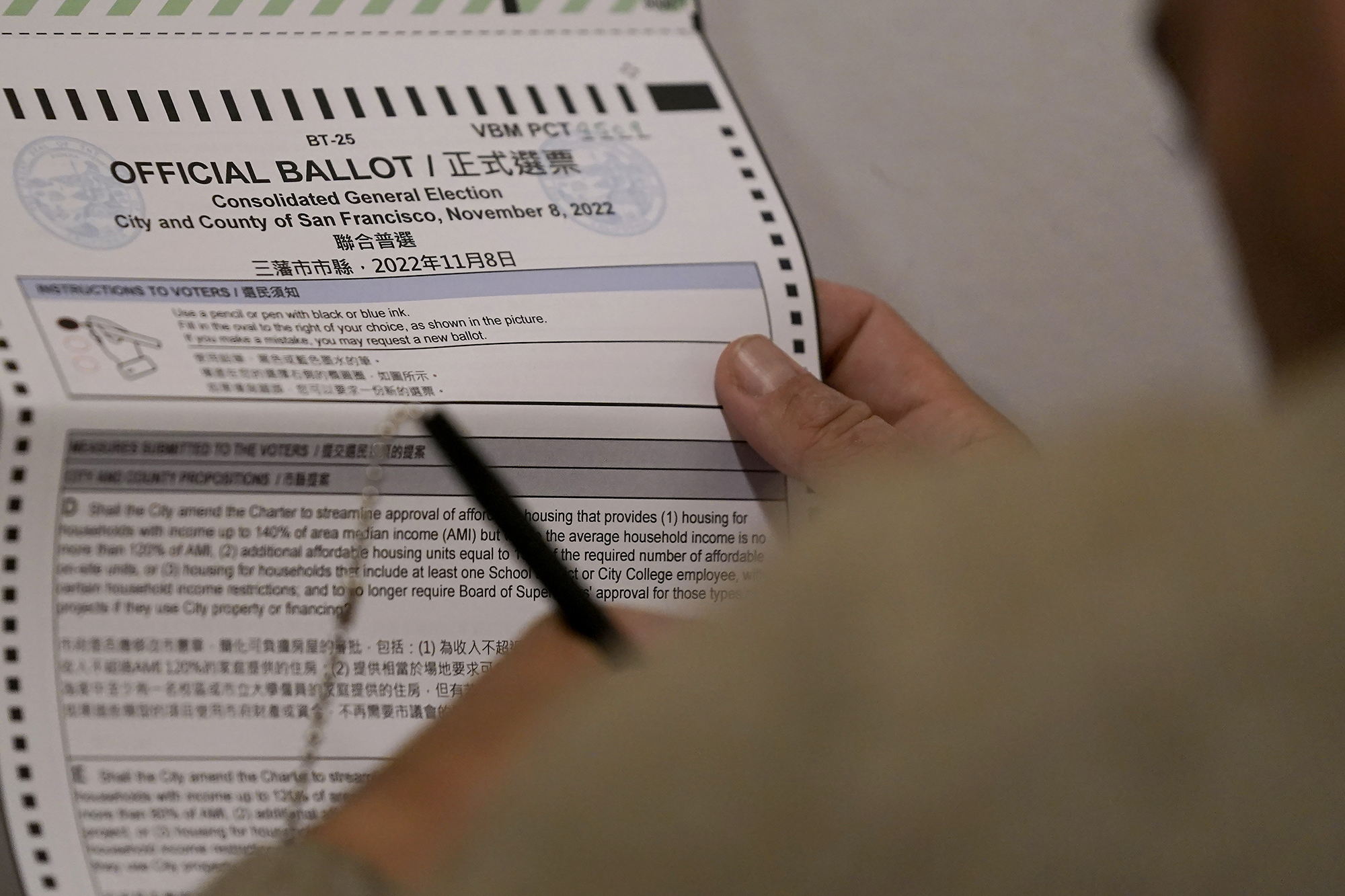 Manny Yekutiel fills out his ballot while voting at City Hall in San Francisco on Tuesday.