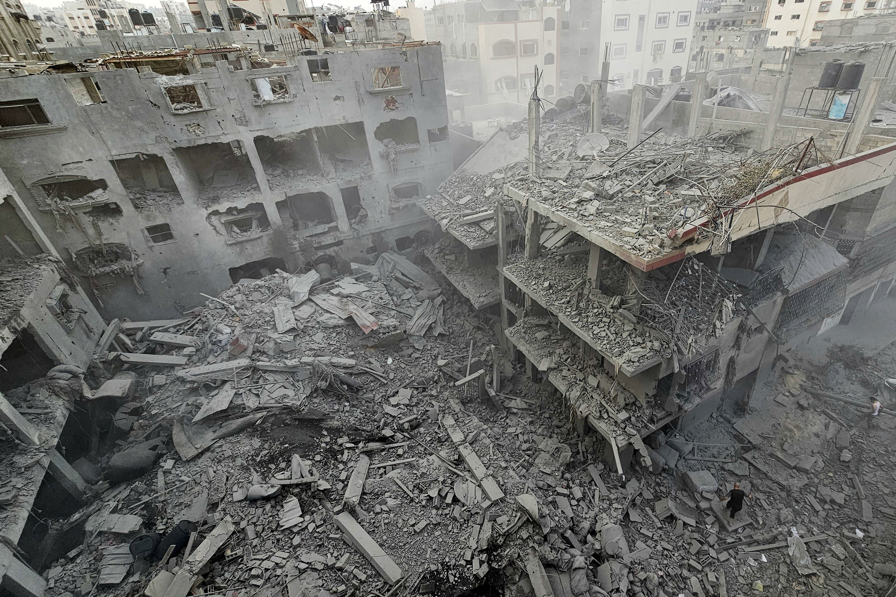 People search through destruction from Israeli strikes in Gaza on Monday.