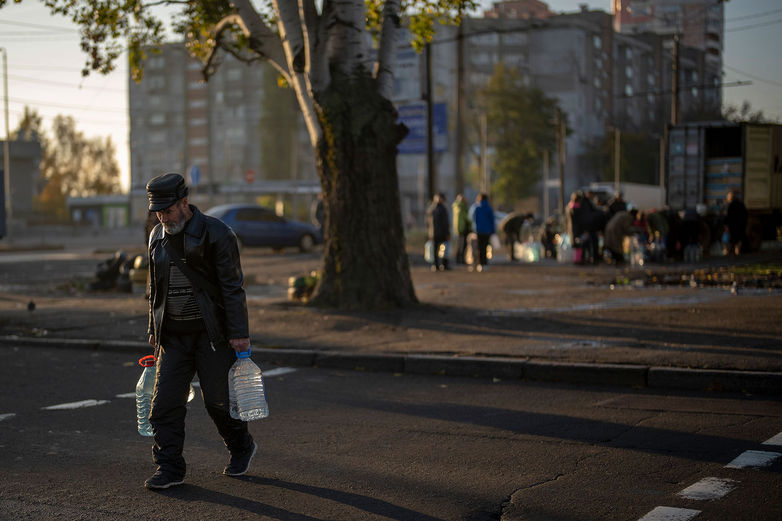 A man carries plastic bottles after refilling them at a tank in Mykolaiv on October 24. 