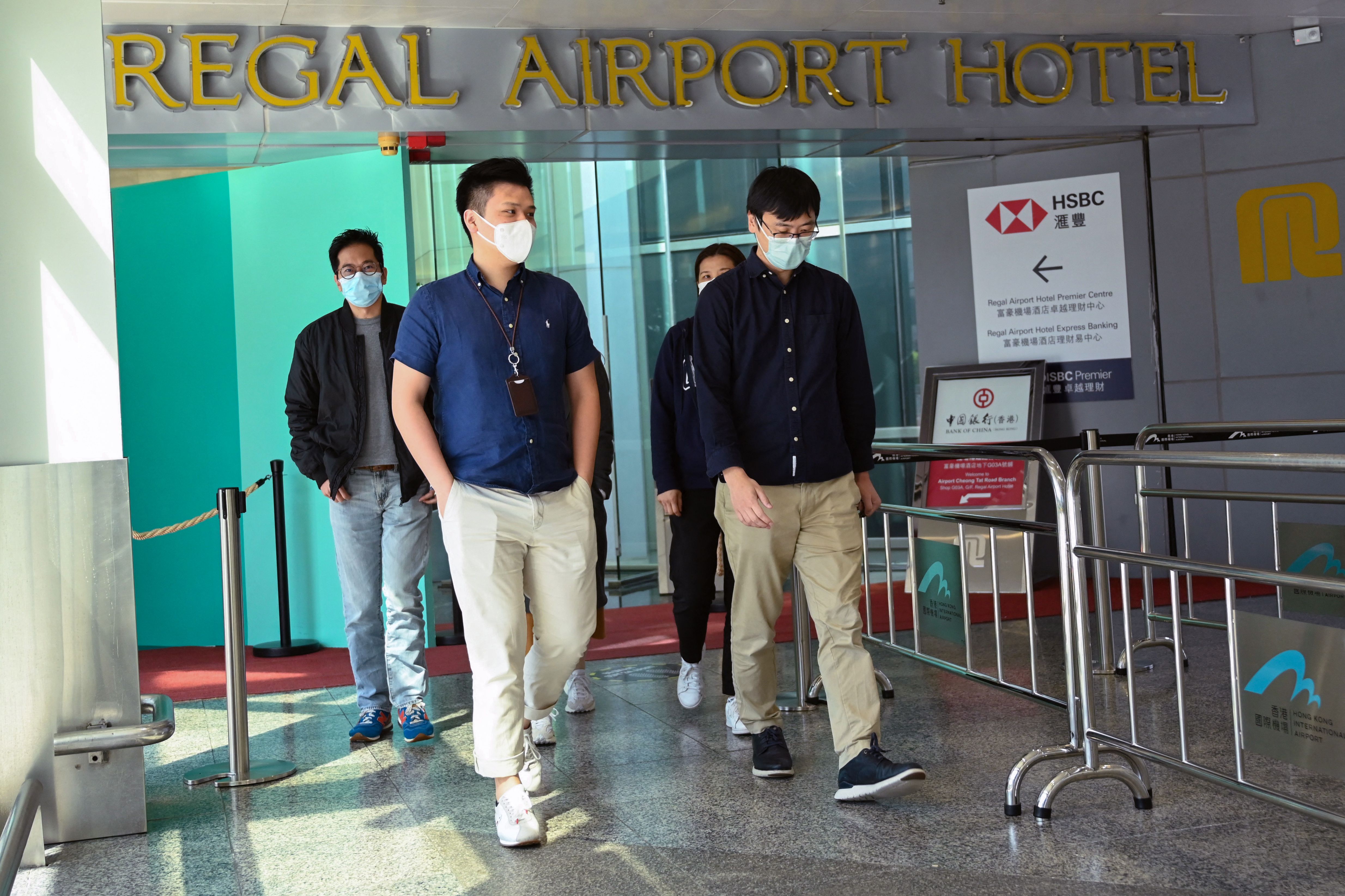 People leave the Regal Airport Hotel at Chek Lap Kok airport in Hong Kong on November 26, 2021, where a new Covid-19 variant deemed a 'major threat' was detected in a traveller from South Africa.