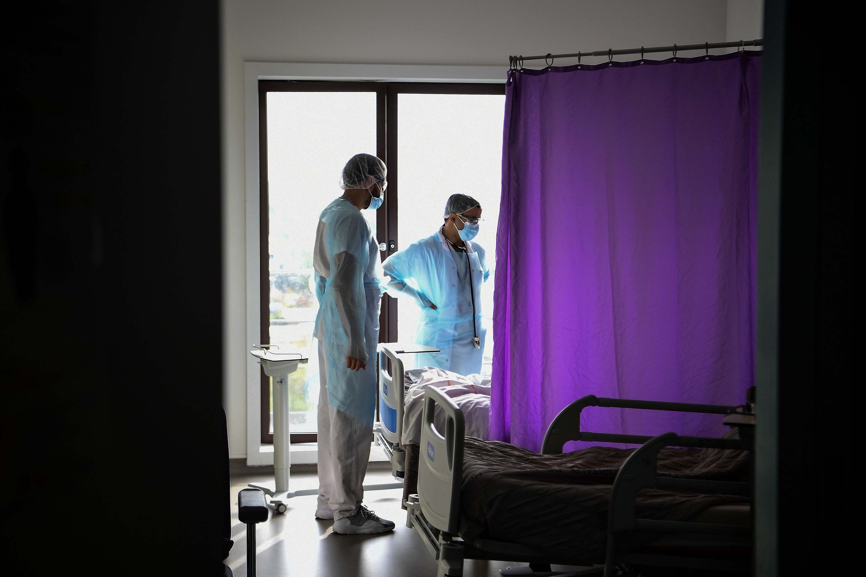 Medical staff members speak to a patient infected with Covid-19 in the infectious diseases unit of the Gonesse hospital in Gonesse, north of Paris, on October 22.