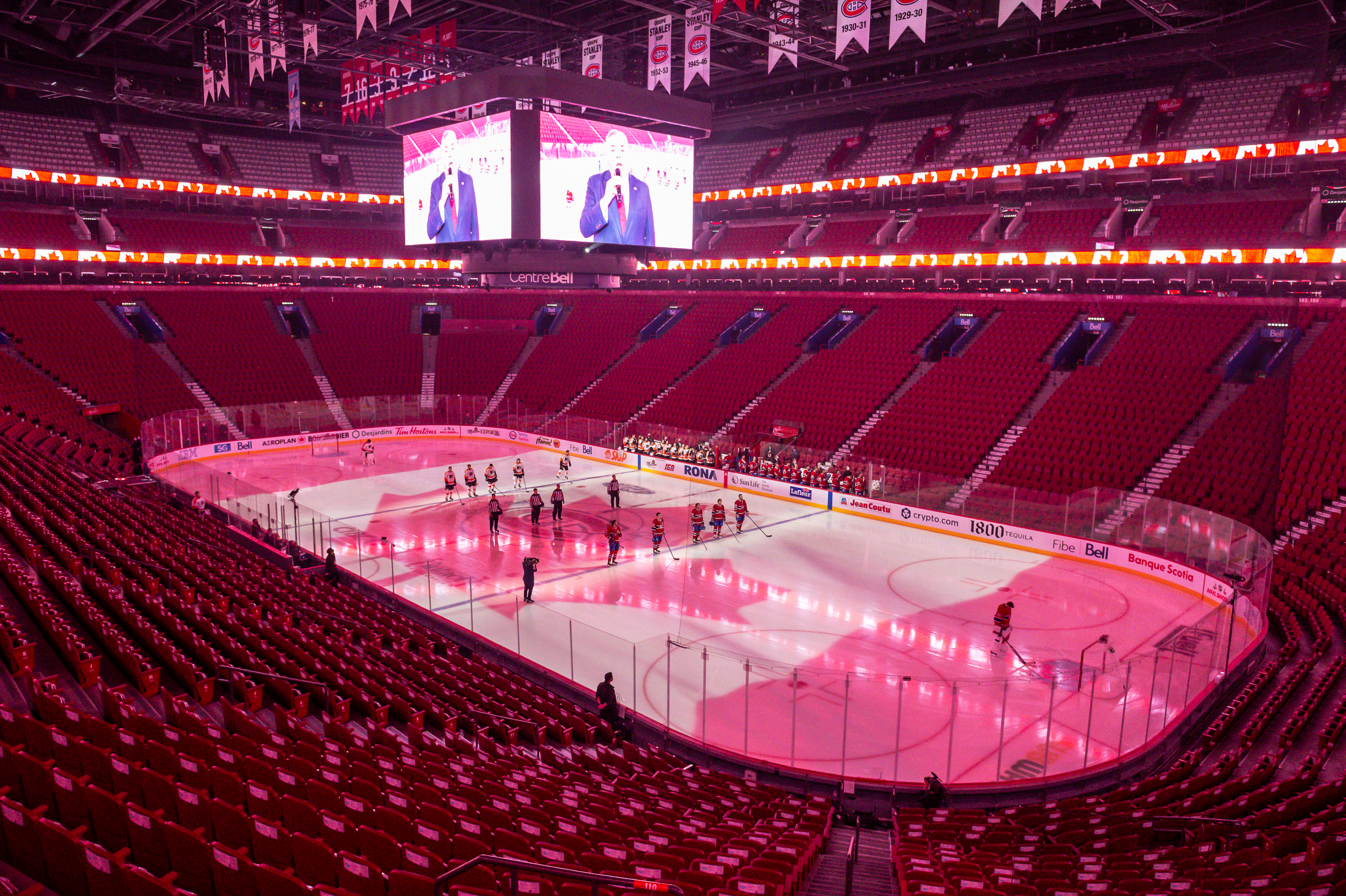 The Montreal Canadiens and the Philadelphia Flyers stand on the ice in an empty arena after the Quebec Government requested that their game be played without spectators at Centre Bell on December 16, in Montreal.