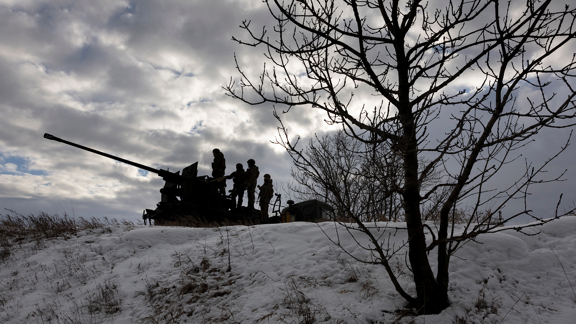 Ukrainian soldiers look towards Russian positions while atop an anti-aircraft gun on February 14 near Bakhmut, Ukraine.