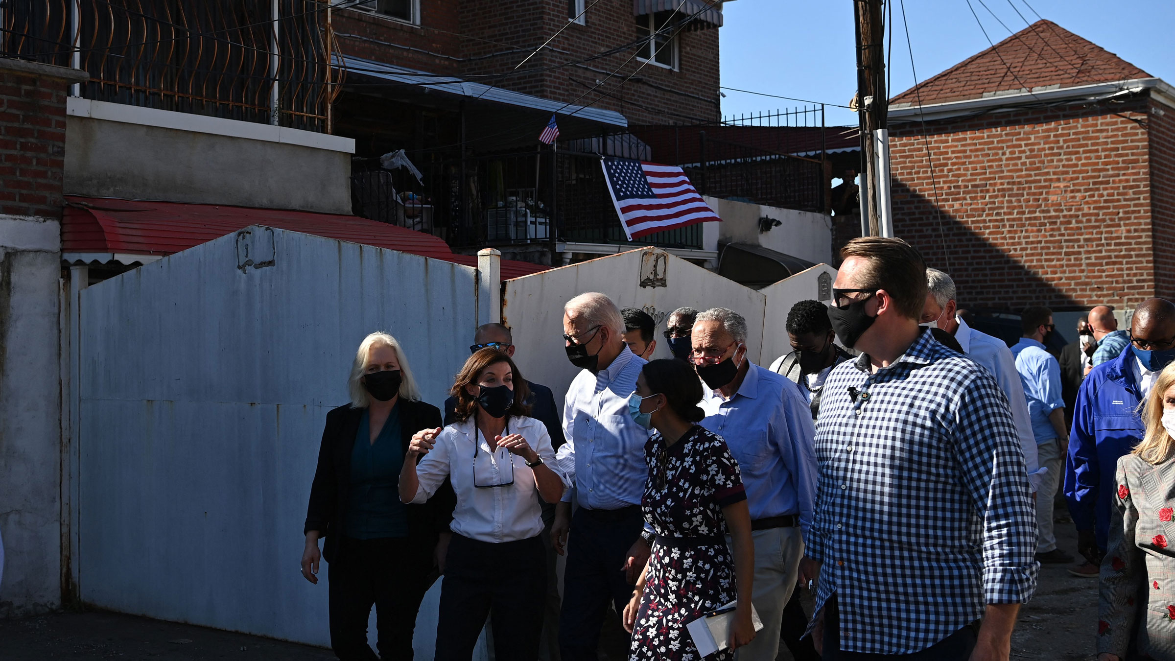 President Joe Biden talks with New York Gov. Kathy Hochul as he tours an Ida-affected neighborhood in Queens, New York, on Tuesday. Also walking with Biden are US Rep. Alexandria Ocasio-Cortez and US Sens. Kirsten Gillibrand and Chuck Schumer.