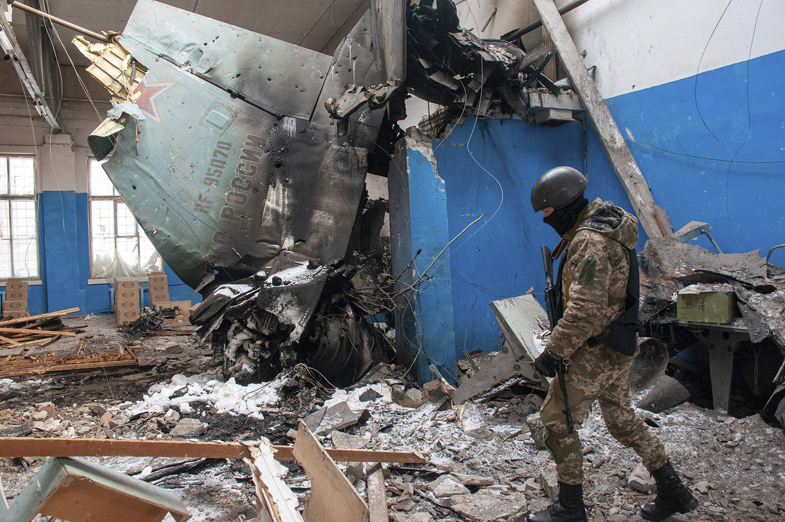 A Ukrainian serviceman walks past the vertical tail fin of a Russian Su-34 bomber lying in a damaged building in Kharkiv, Ukraine, on March 8.