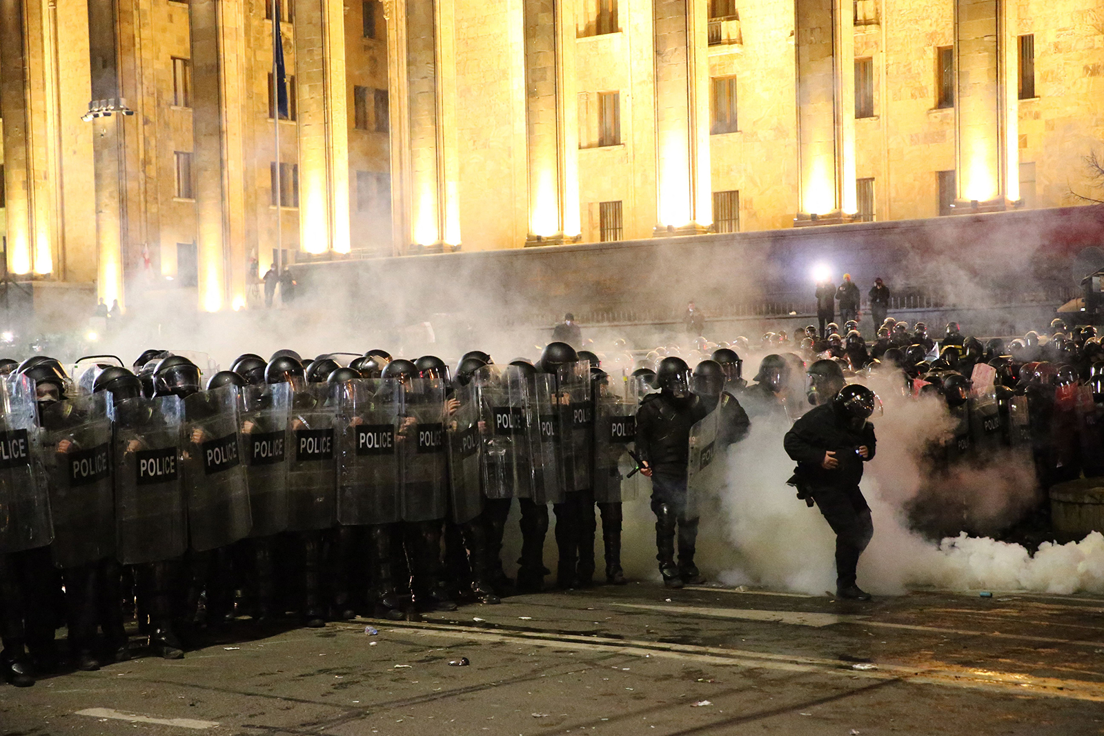 Police in riot gear face protesters in Tbilisi early on March 9.