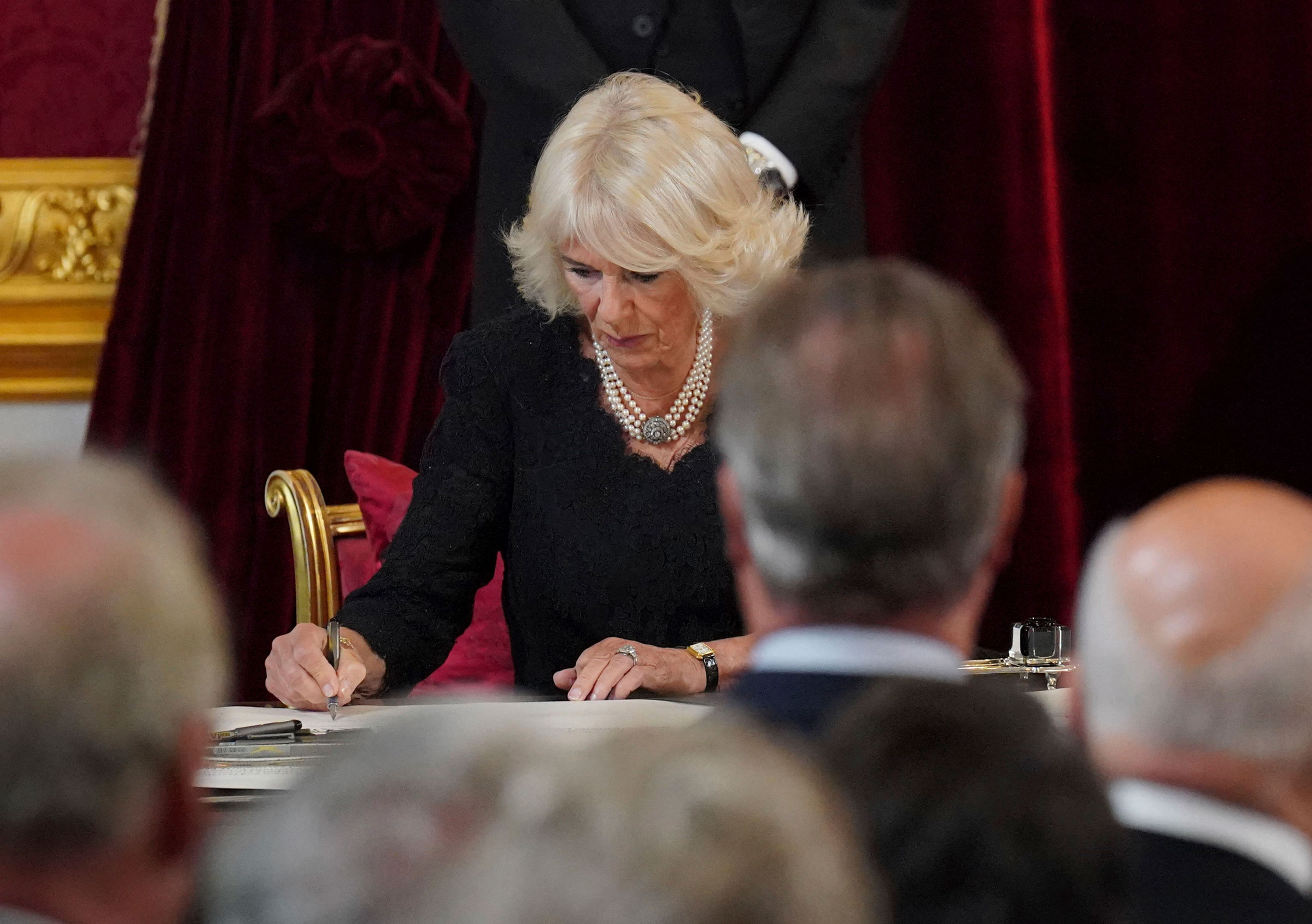 Camilla, the Queen Consort, signs an oath during the meeting of the Accession Council.