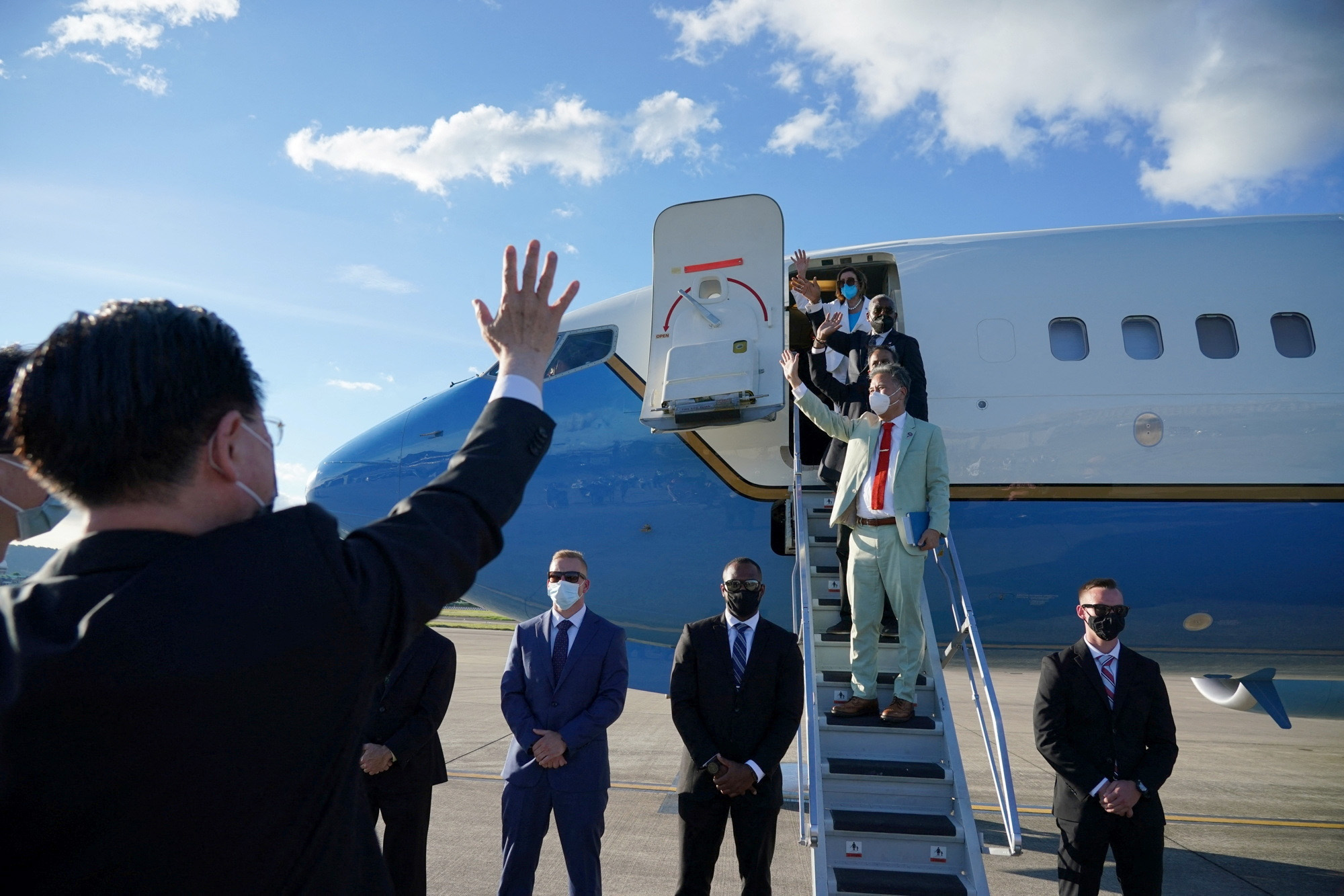 Taiwan Foreign Minister Joseph Wu waves at U.S. House of Representatives Speaker Nancy Pelosi and other members of the delegation as they board a plane before leaving Taipei Songshan Airport, in Taipei, Taiwan, on August 3.