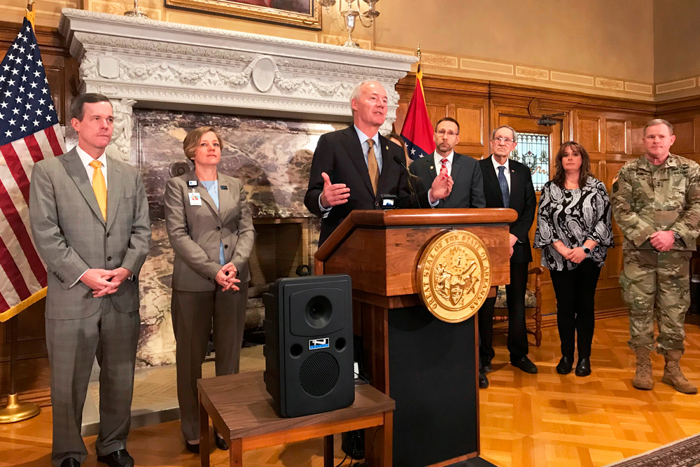 Arkansas Gov. Asa Hutchinson, center, speaks at a news conference at the state Capitol on Thursday, March 12.