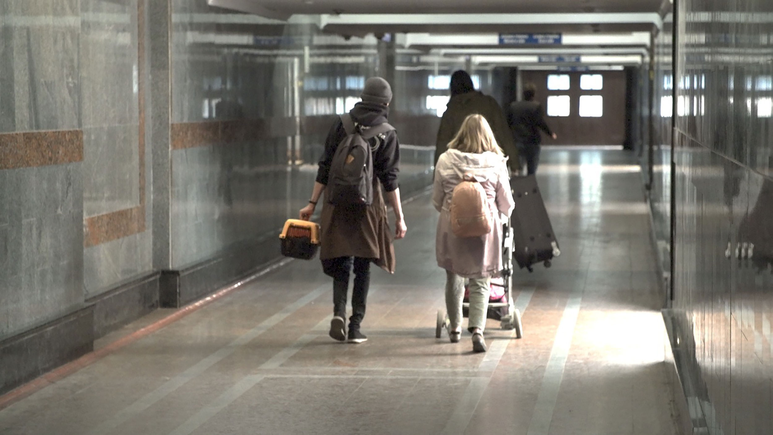 Ukrainians Luba and Rodion walk through the Lviv train station.