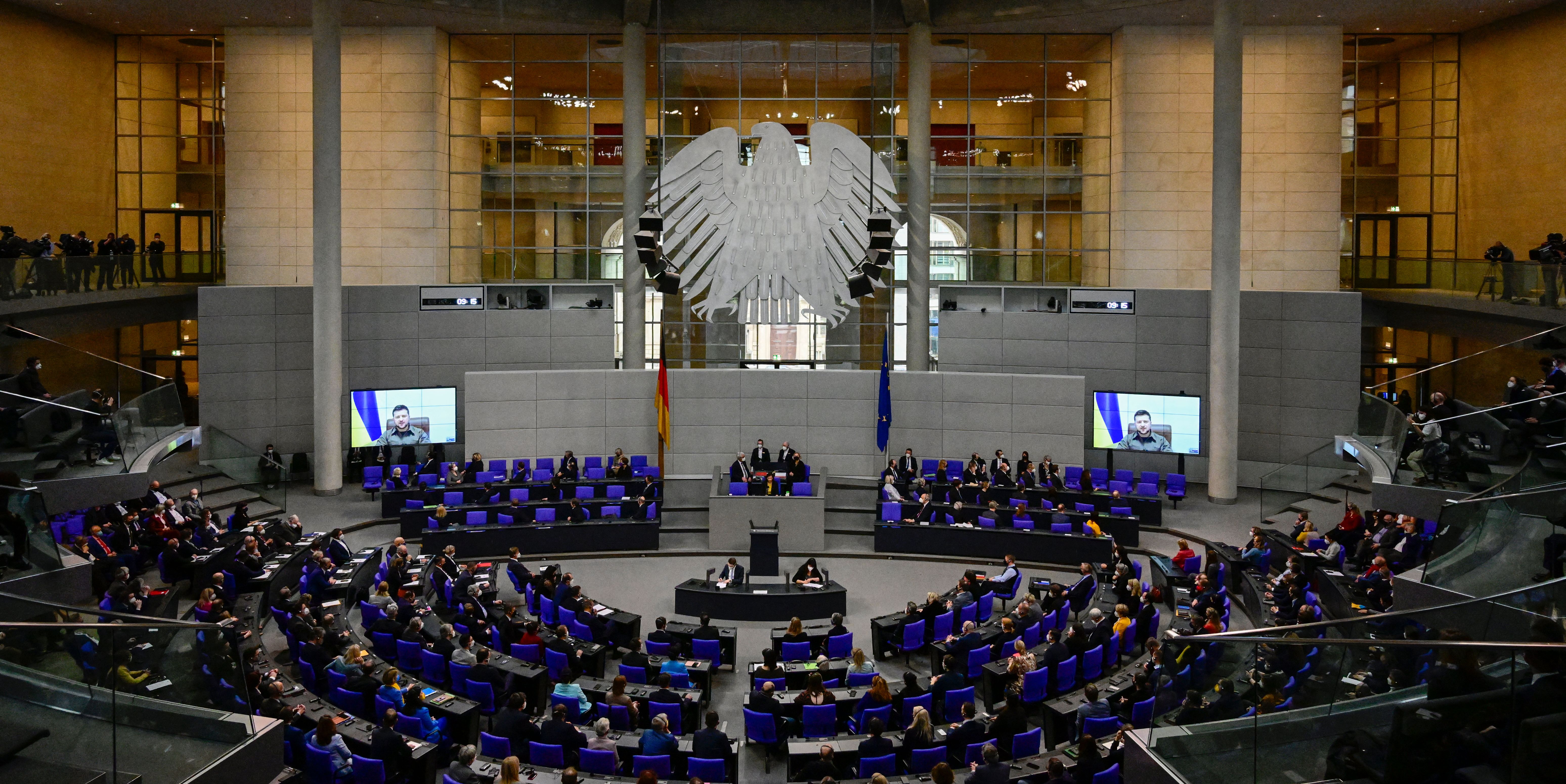 Members of parliament and of the German government listen as Ukrainian President Volodymyr Zelensky appears on two screens to address via videolink the German Bundestag on March 17, in Berlin, Germany.