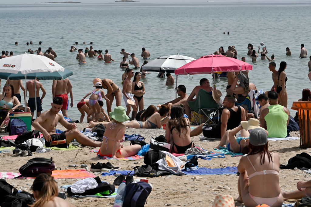Beachgoers enjoy the sun and sea at public beach during the official reopening of beaches to the public on May 16 in Varkiza, Greece. 